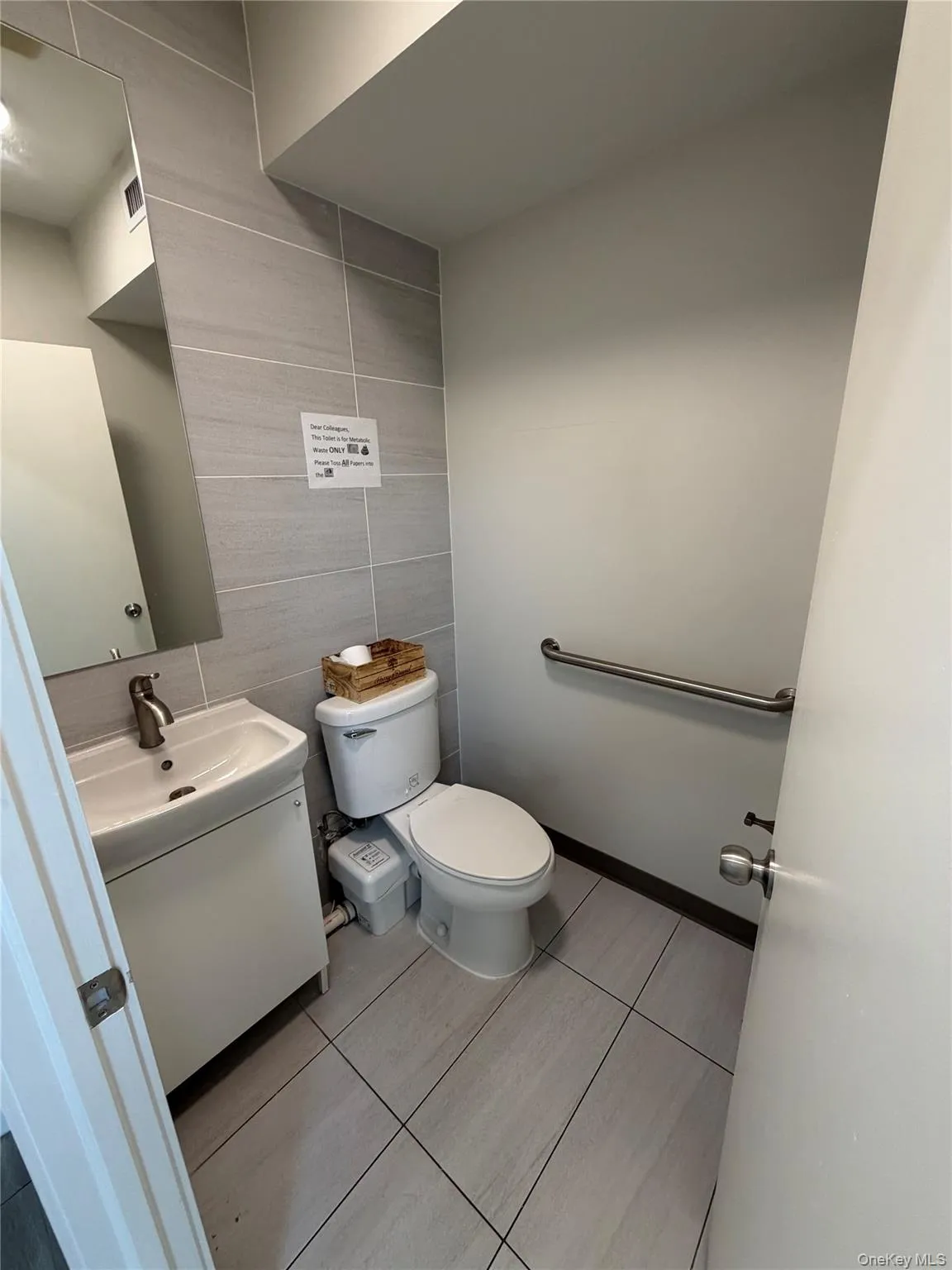 Half bath with tile walls, vanity, and light tile patterned floors Half bath with tile walls, vanity, and light tile patterned floors