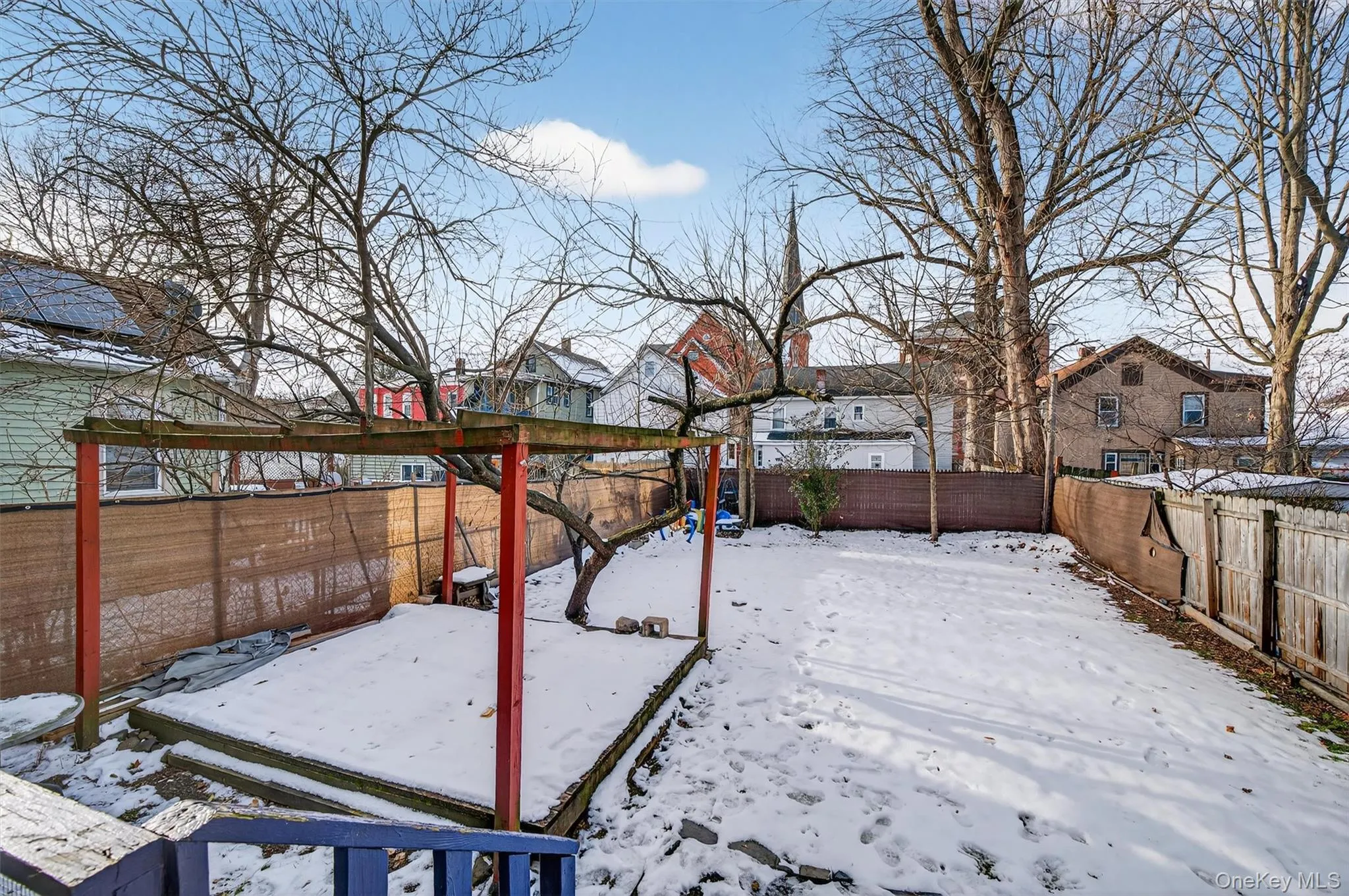 Yard covered in snow featuring a fenced backyard and a residential view Yard covered in snow featuring a fenced backyard and a residential view