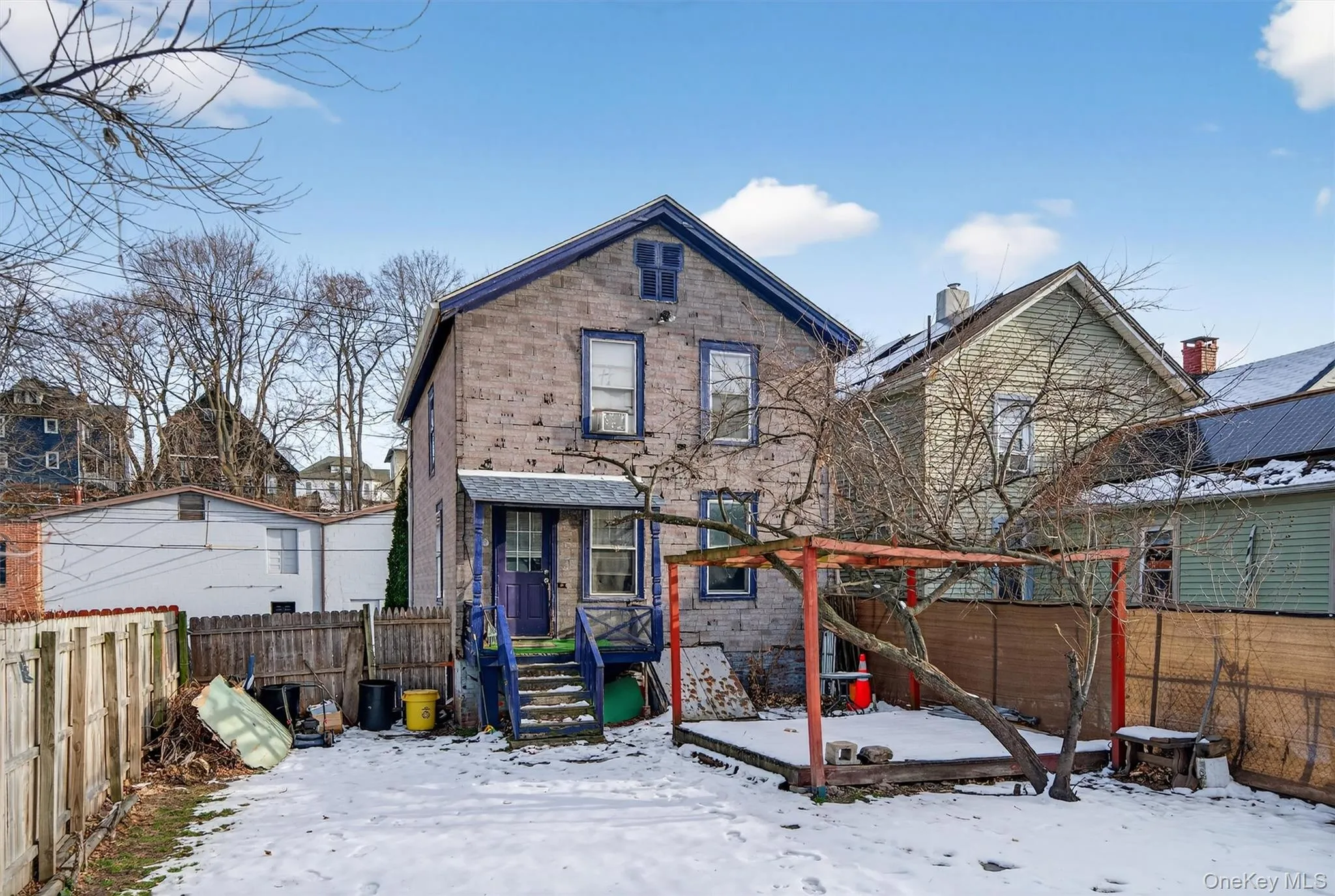Snow covered back of property featuring a fenced backyard and a wooden deck Snow covered back of property featuring a fenced backyard and a wooden deck