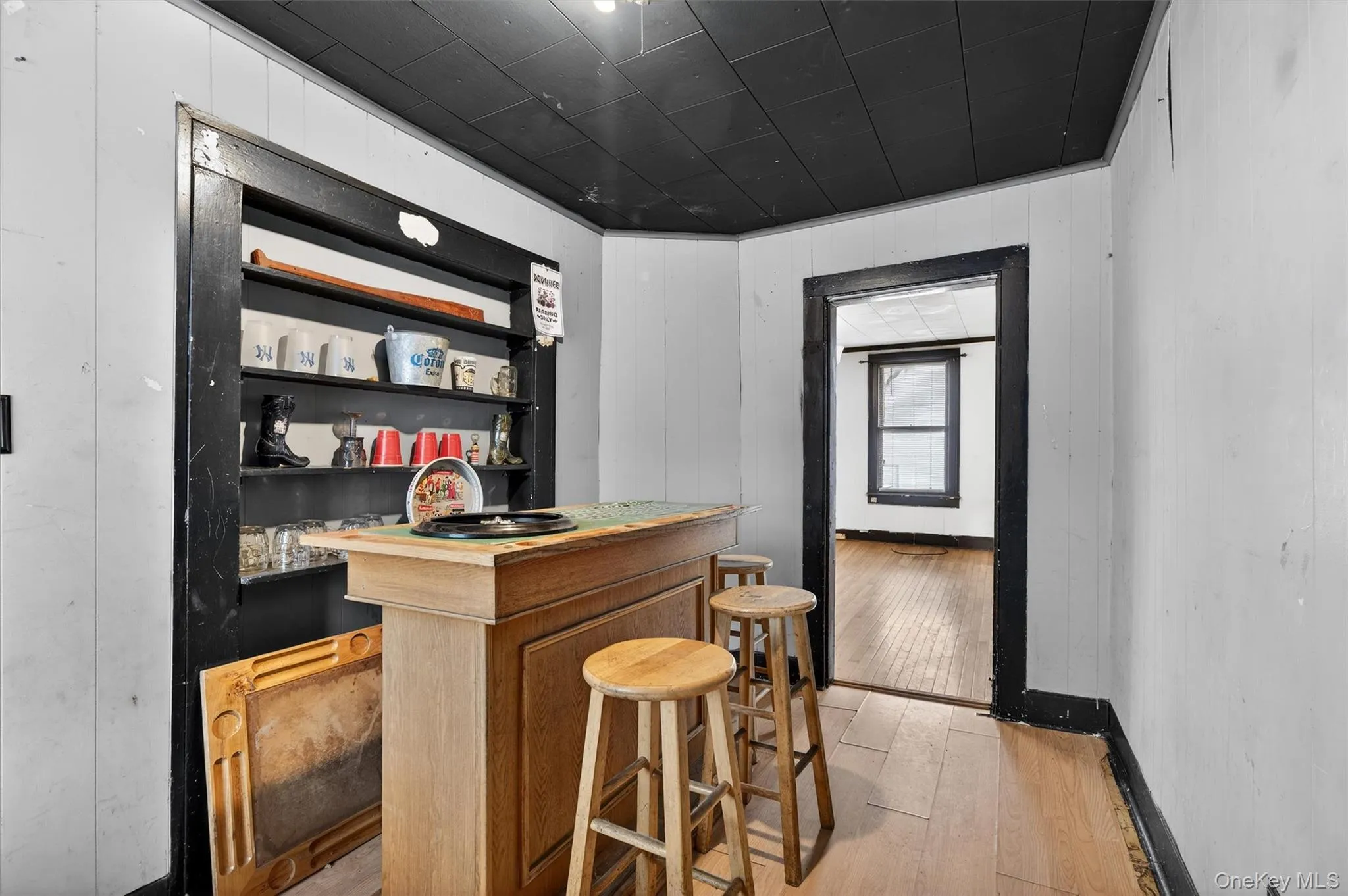 Indoor dry bar with light wood-type flooring and open shelves Indoor dry bar with light wood-type flooring and open shelves