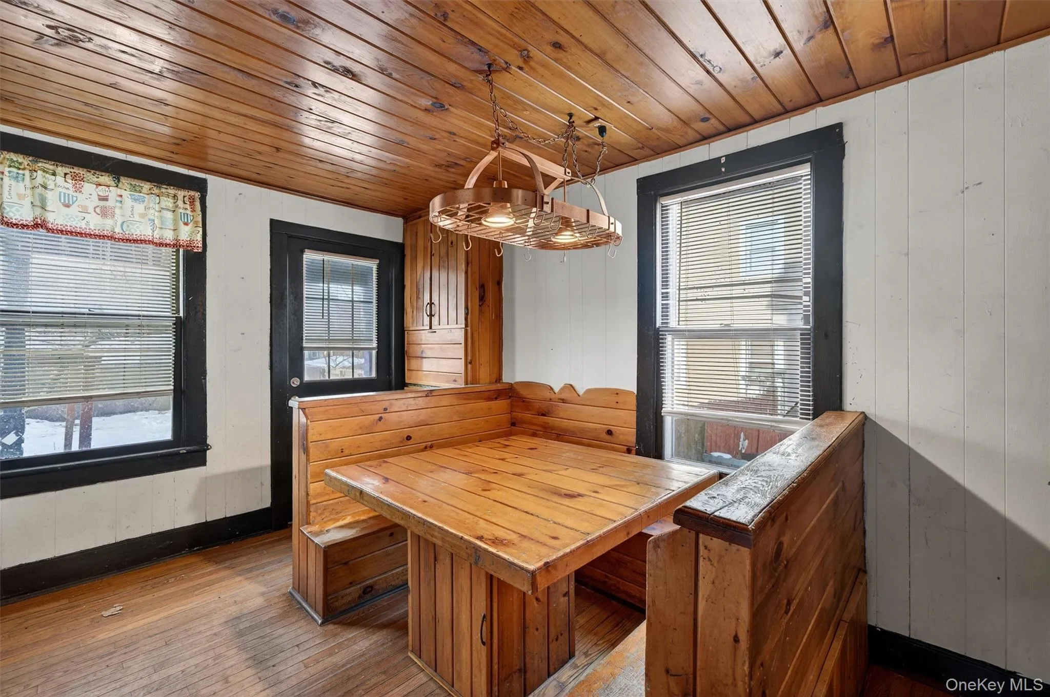 Dining space featuring wood ceiling, wood walls, and wood-type flooring Dining space featuring wood ceiling, wood walls, and wood-type flooring