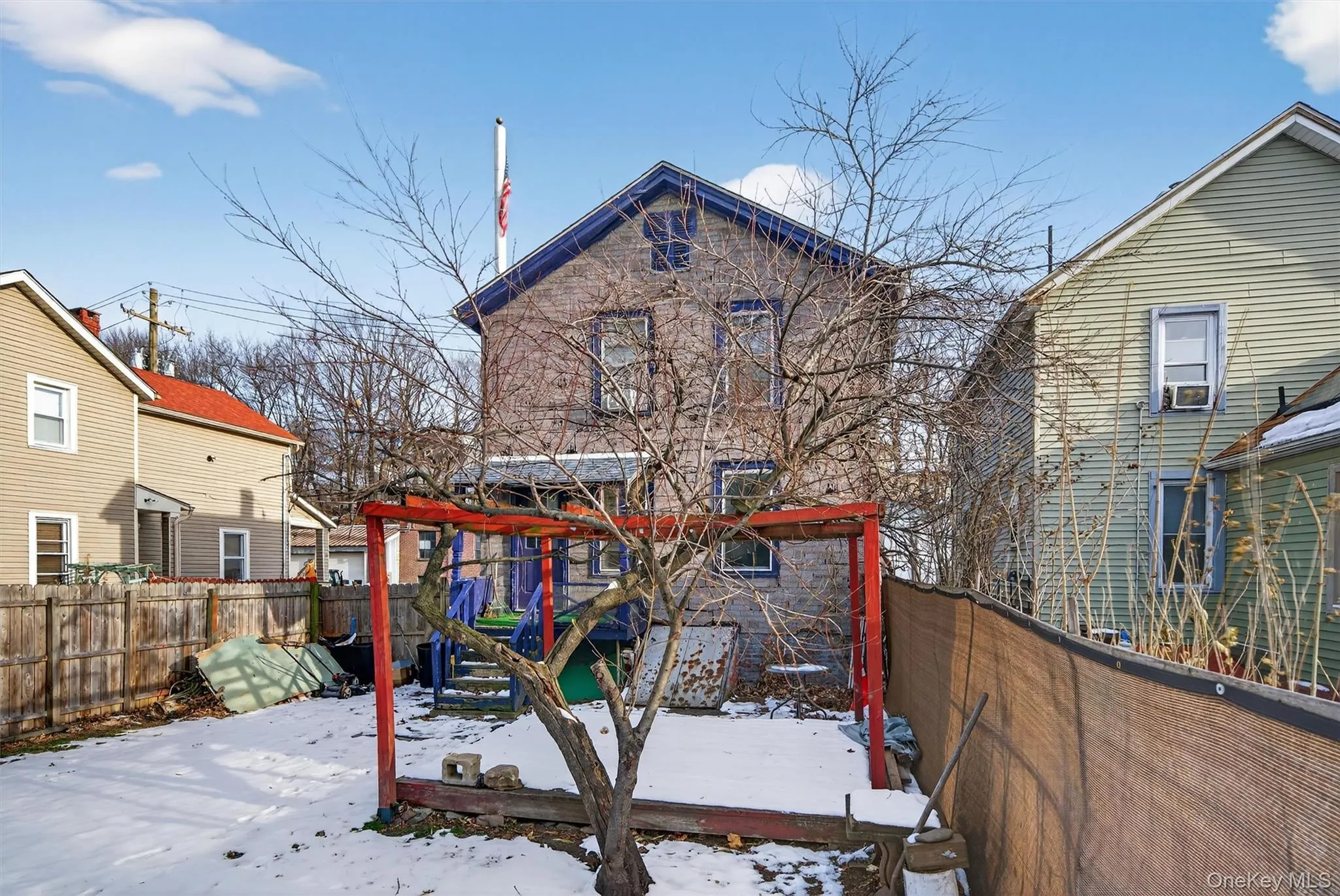 Snow covered house with a fenced backyard and a wooden deck Snow covered house with a fenced backyard and a wooden deck