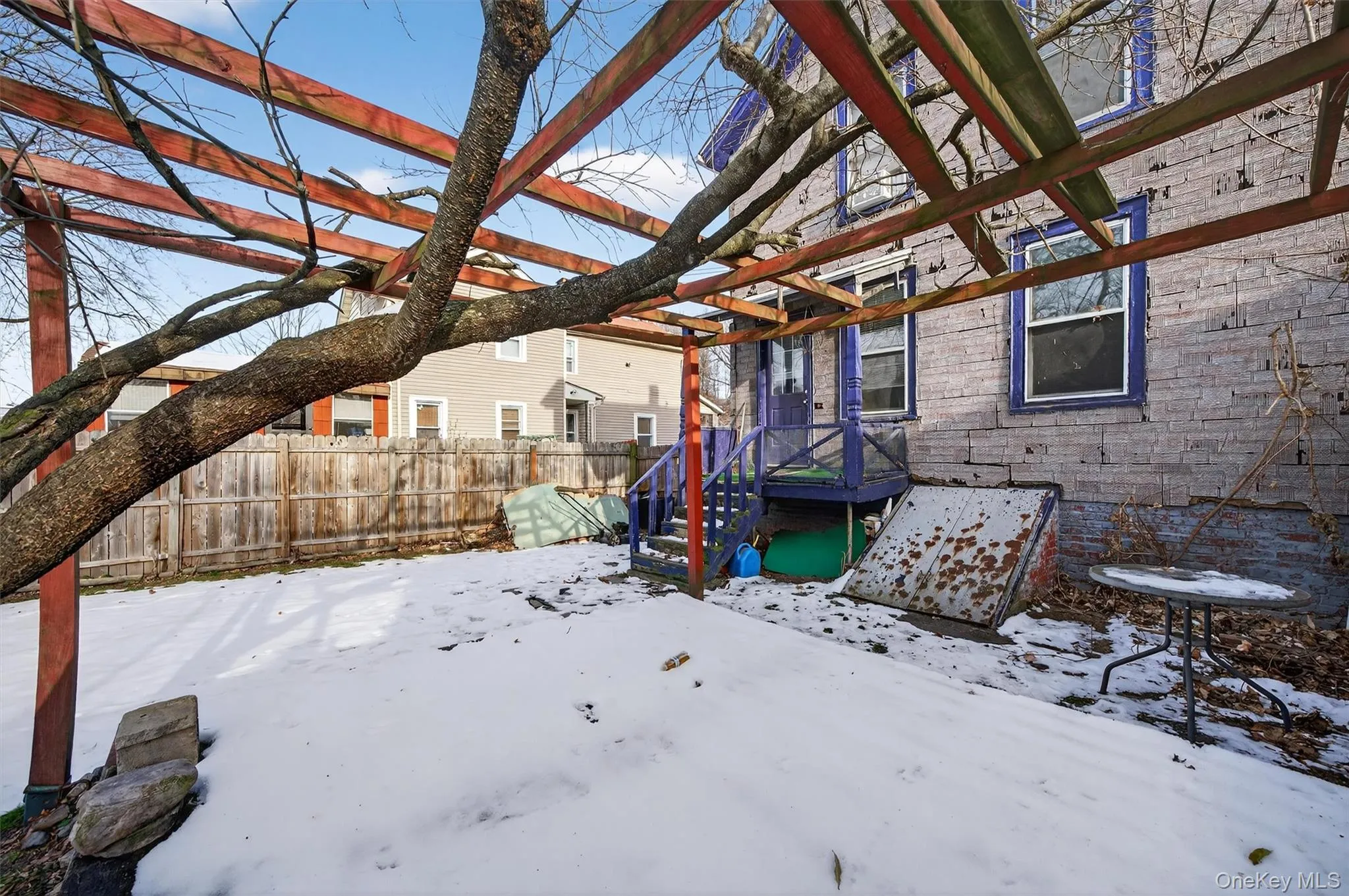Yard layered in snow with a wooden deck Yard layered in snow with a wooden deck