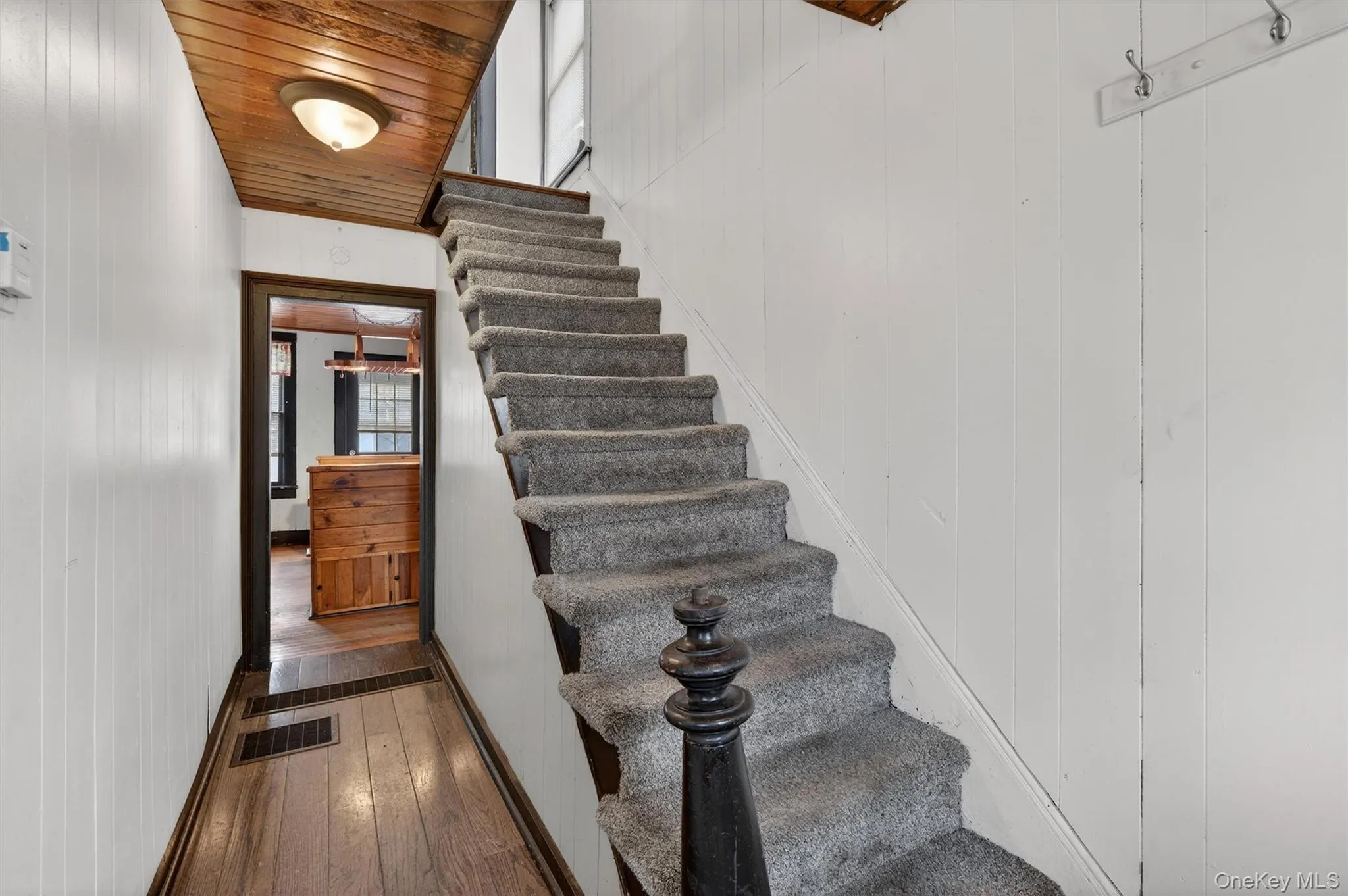Stairs with wooden walls, wood-type flooring, and wooden ceiling Stairs with wooden walls, wood-type flooring, and wooden ceiling