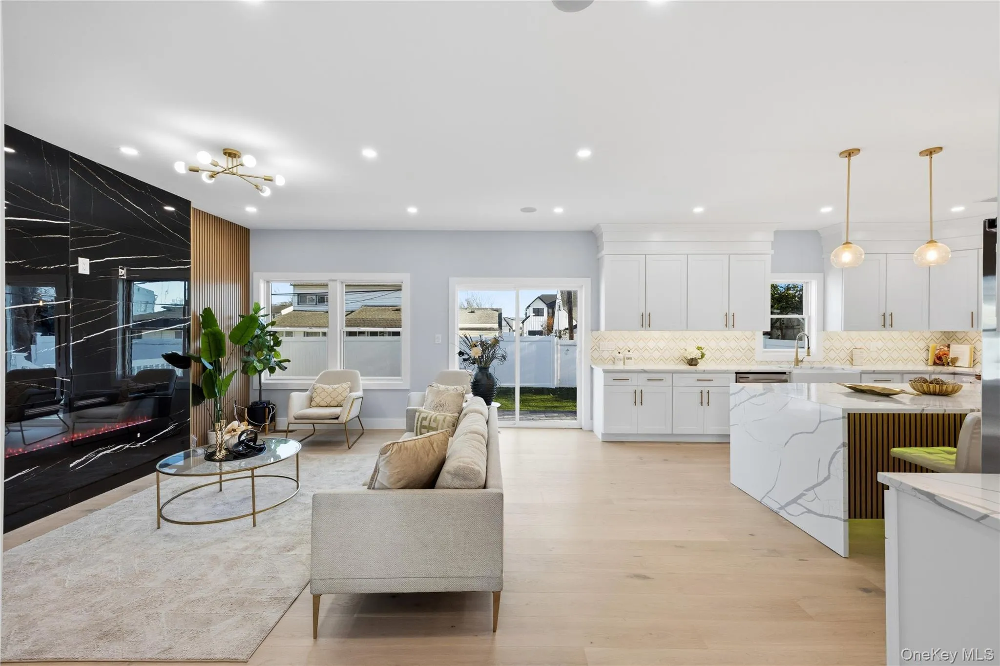 Living room with light wood-style floors, a chandelier, and recessed lighting Living room with light wood-style floors, a chandelier, and recessed lighting