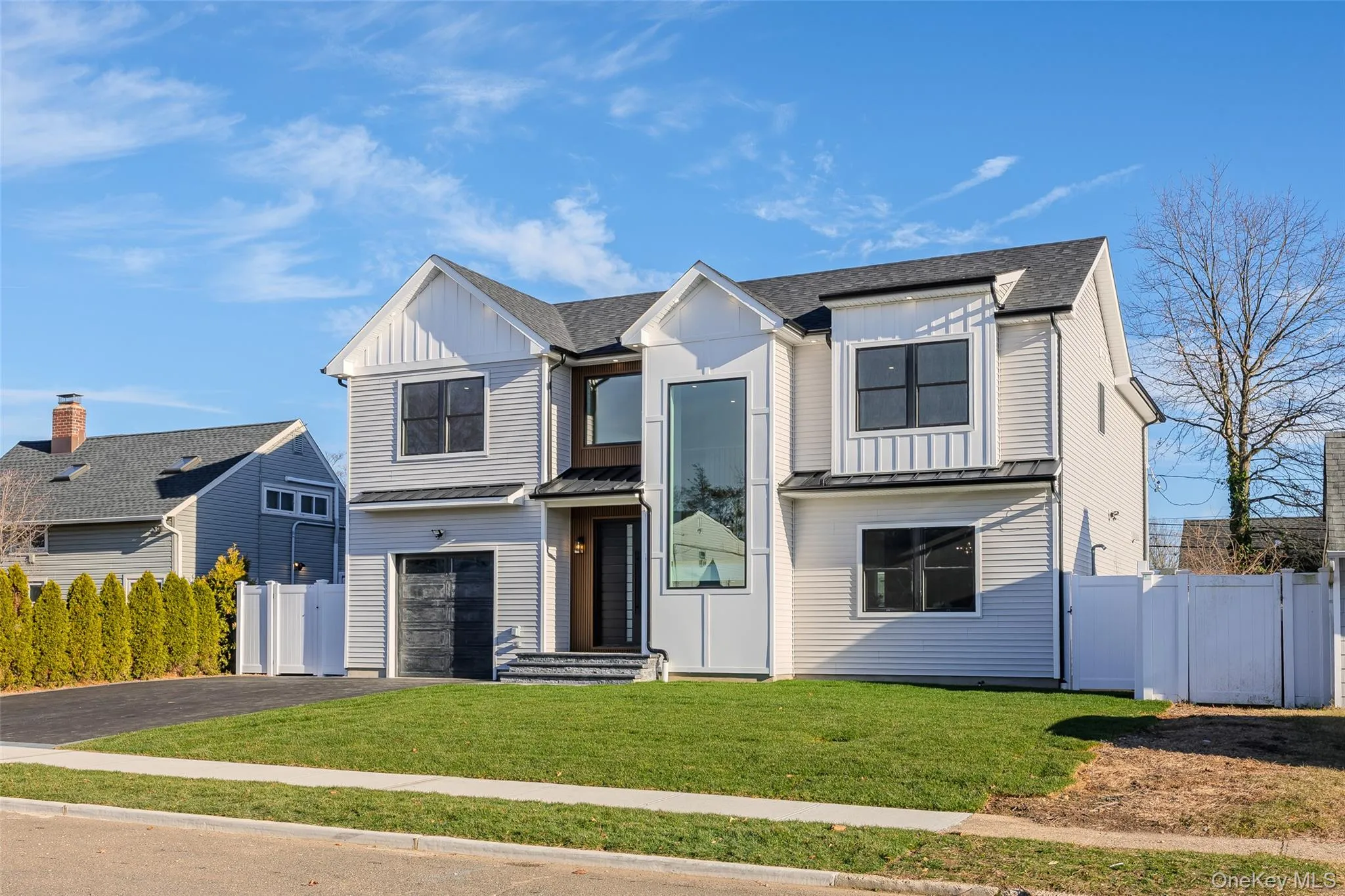 Modern inspired farmhouse with board and batten siding, driveway, a garage, and roof with shingles Modern inspired farmhouse with board and batten siding, driveway, a garage, and roof with shingles