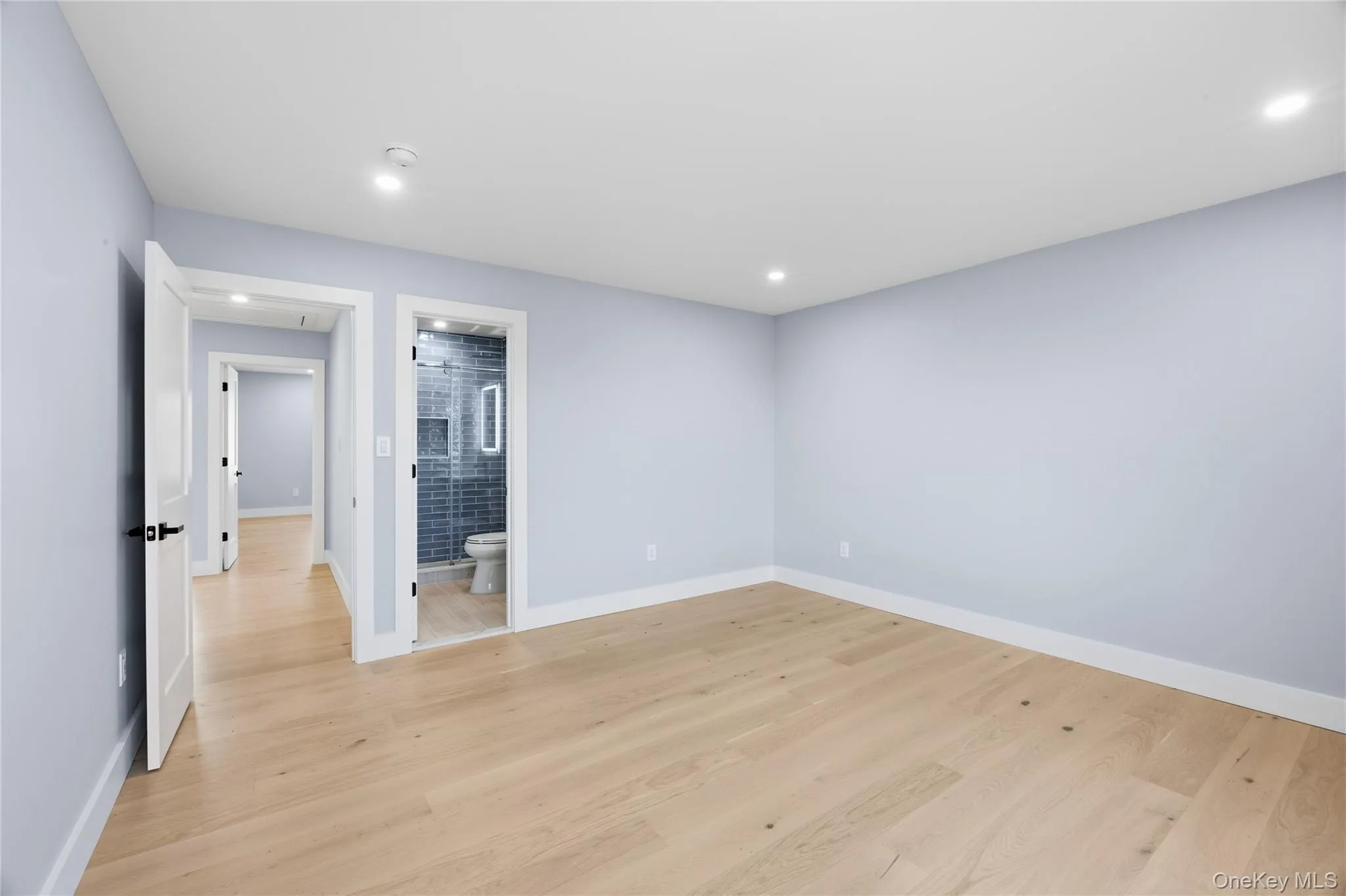 Unfurnished bedroom with light wood-style flooring, recessed lighting, and connected bathroom Unfurnished bedroom with light wood-style flooring, recessed lighting, and connected bathroom