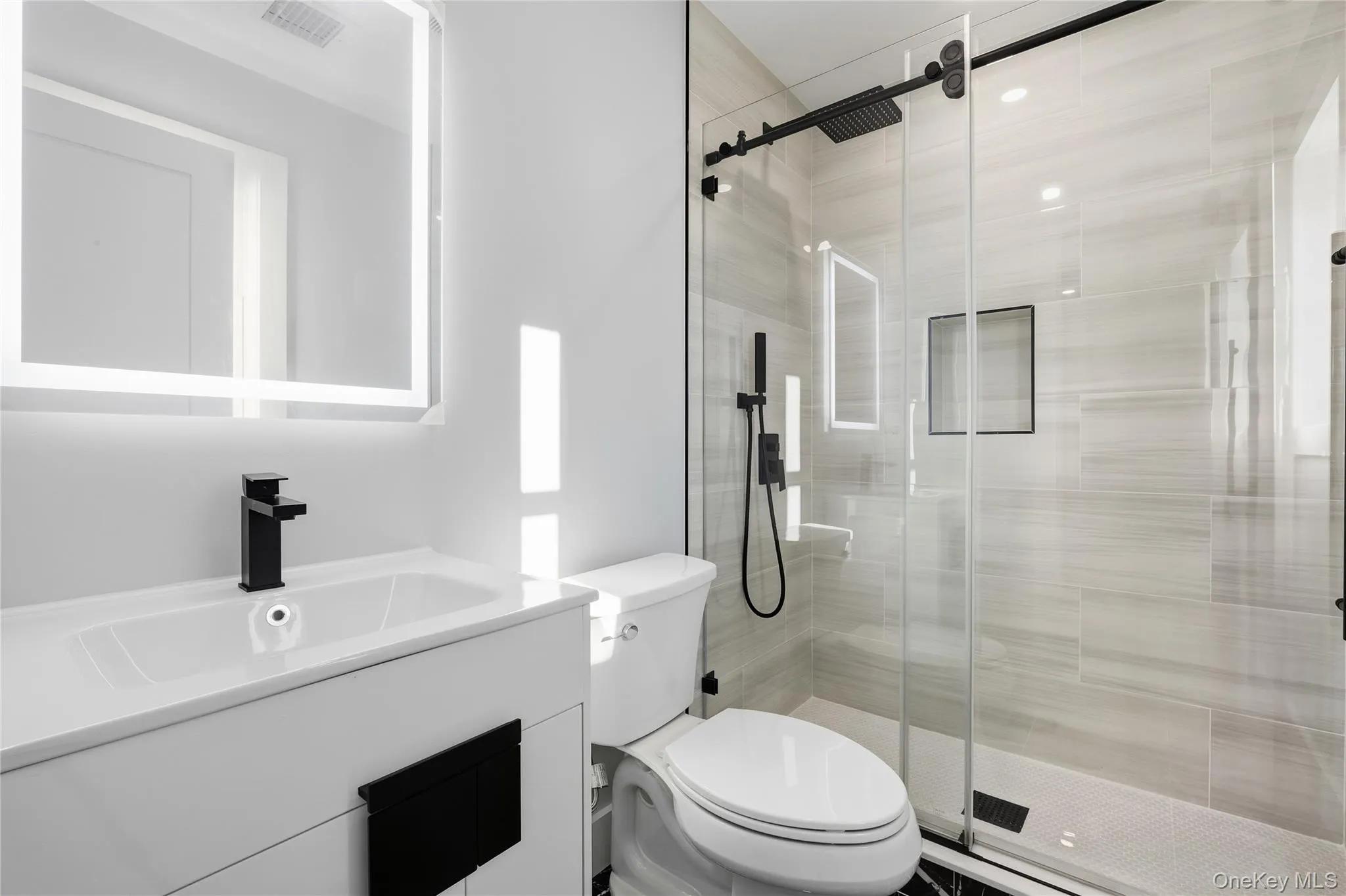 Bathroom with vanity and a shower stall Bathroom with vanity and a shower stall