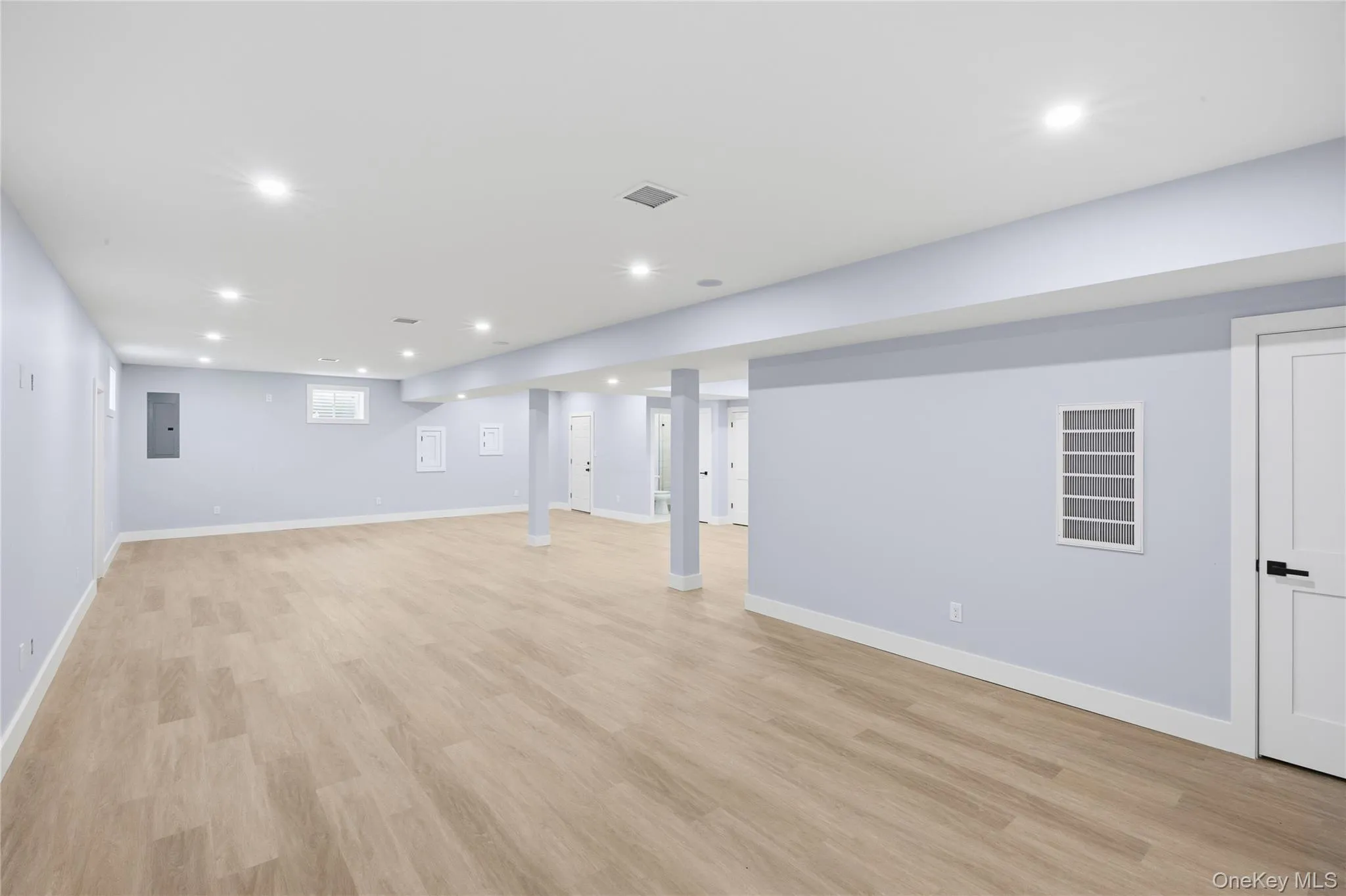 Below grade area featuring recessed lighting, light wood-style flooring, and electric panel Below grade area featuring recessed lighting, light wood-style flooring, and electric panel