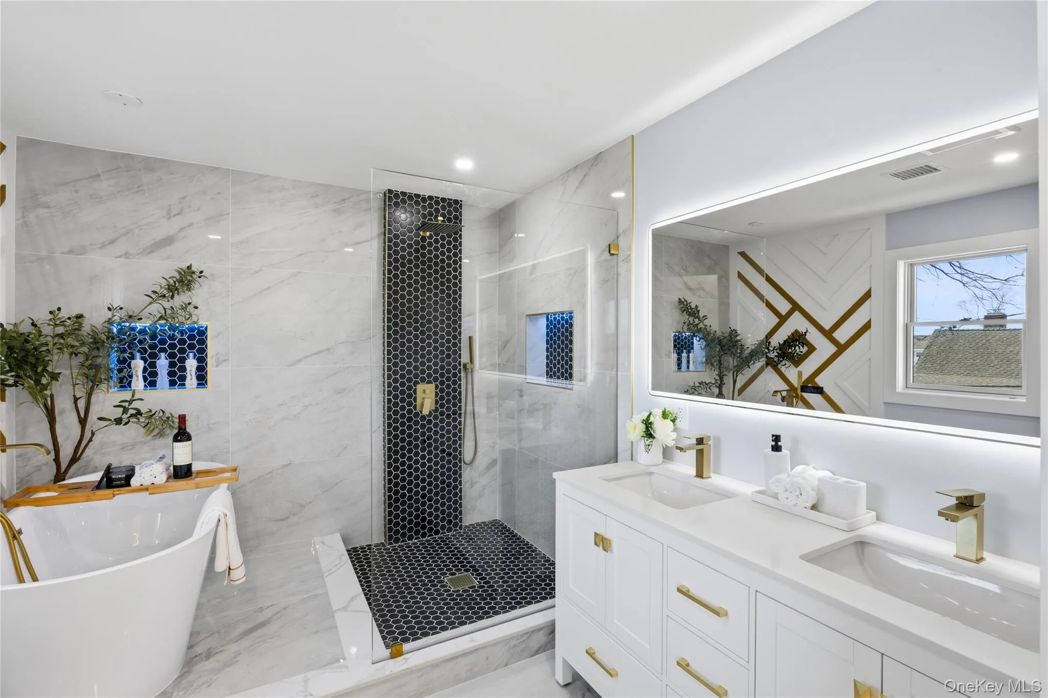 Bathroom with double vanity, a freestanding bath, walk in shower, and light marble finish flooring Bathroom with double vanity, a freestanding bath, walk in shower, and light marble finish flooring