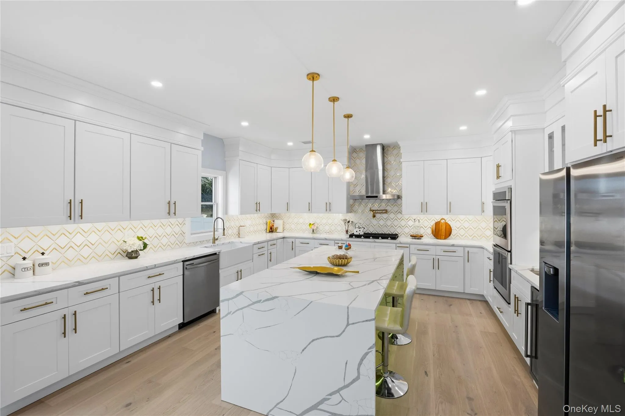 Kitchen featuring light stone counters, pendant lighting, stainless steel appliances, white cabinets, and a center island Kitchen featuring light stone counters, pendant lighting, stainless steel appliances, white cabinets, and a center island