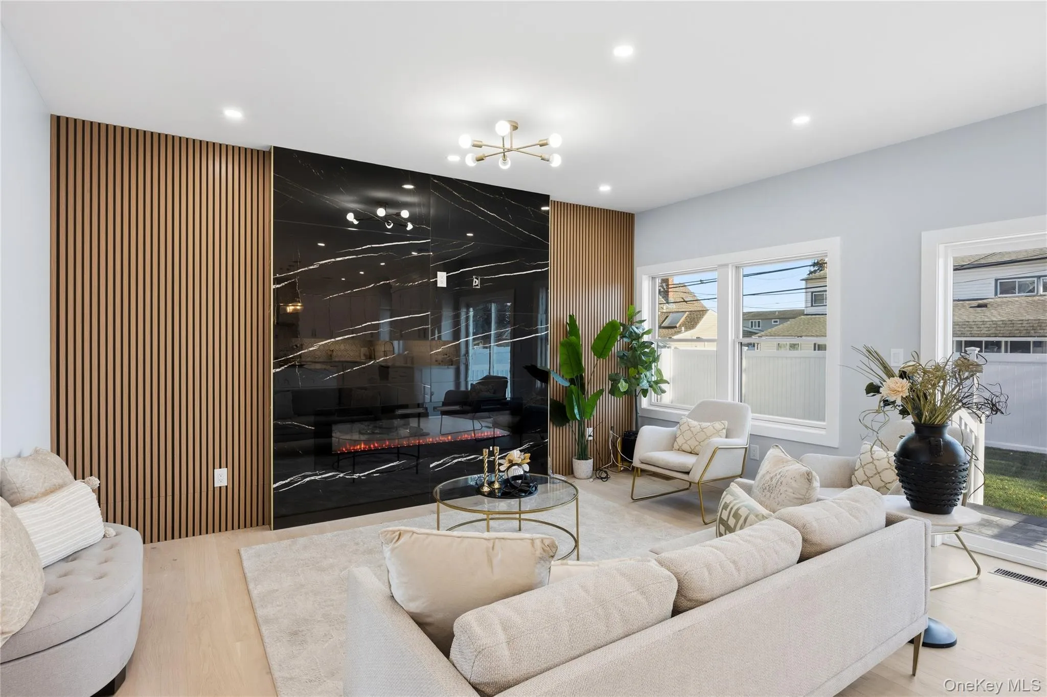 Living area with an accent wall, recessed lighting, wood finished floors, and a chandelier Living area with an accent wall, recessed lighting, wood finished floors, and a chandelier