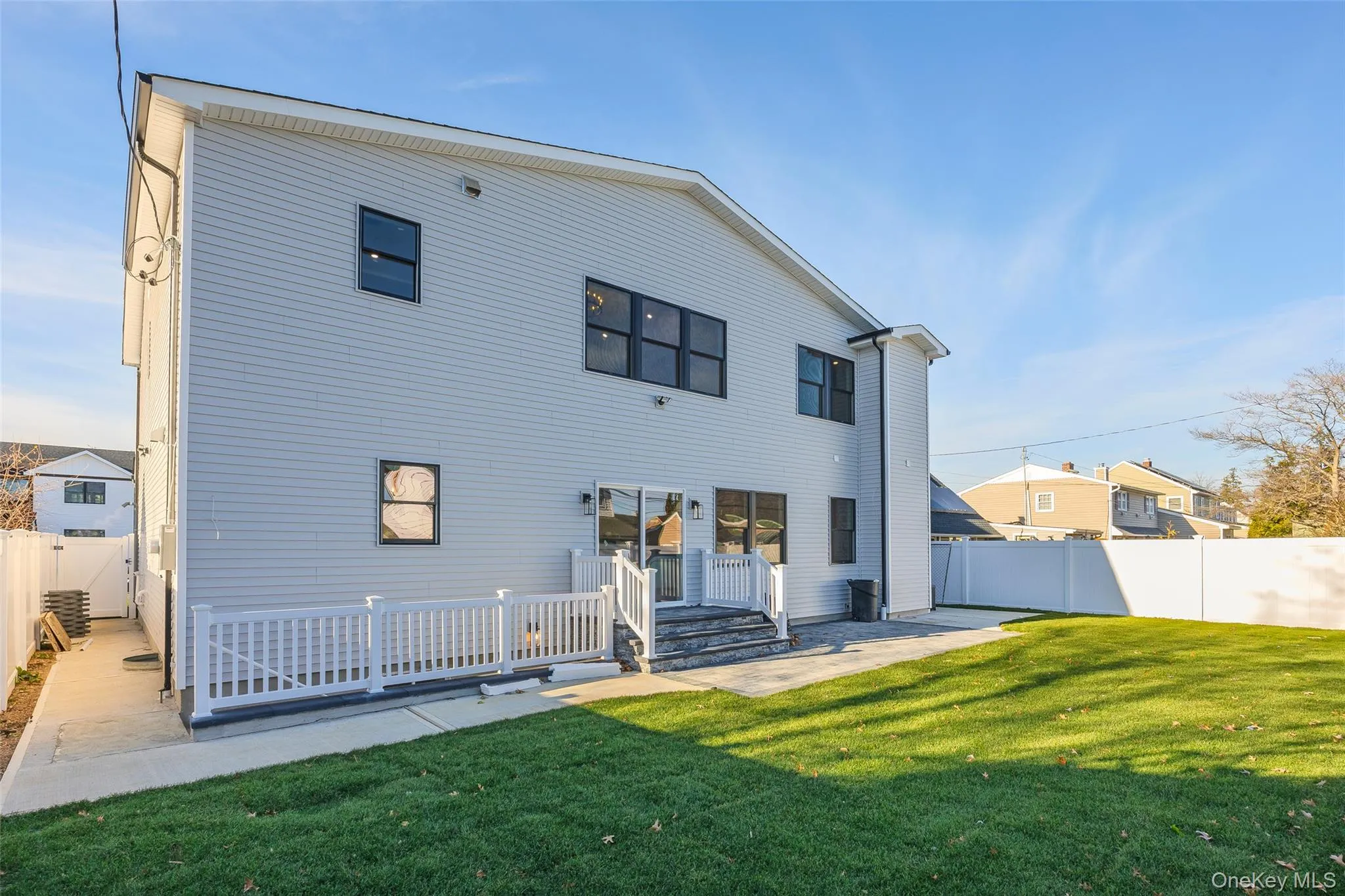 Back of property featuring a fenced backyard, a wooden deck, and a patio Back of property featuring a fenced backyard, a wooden deck, and a patio