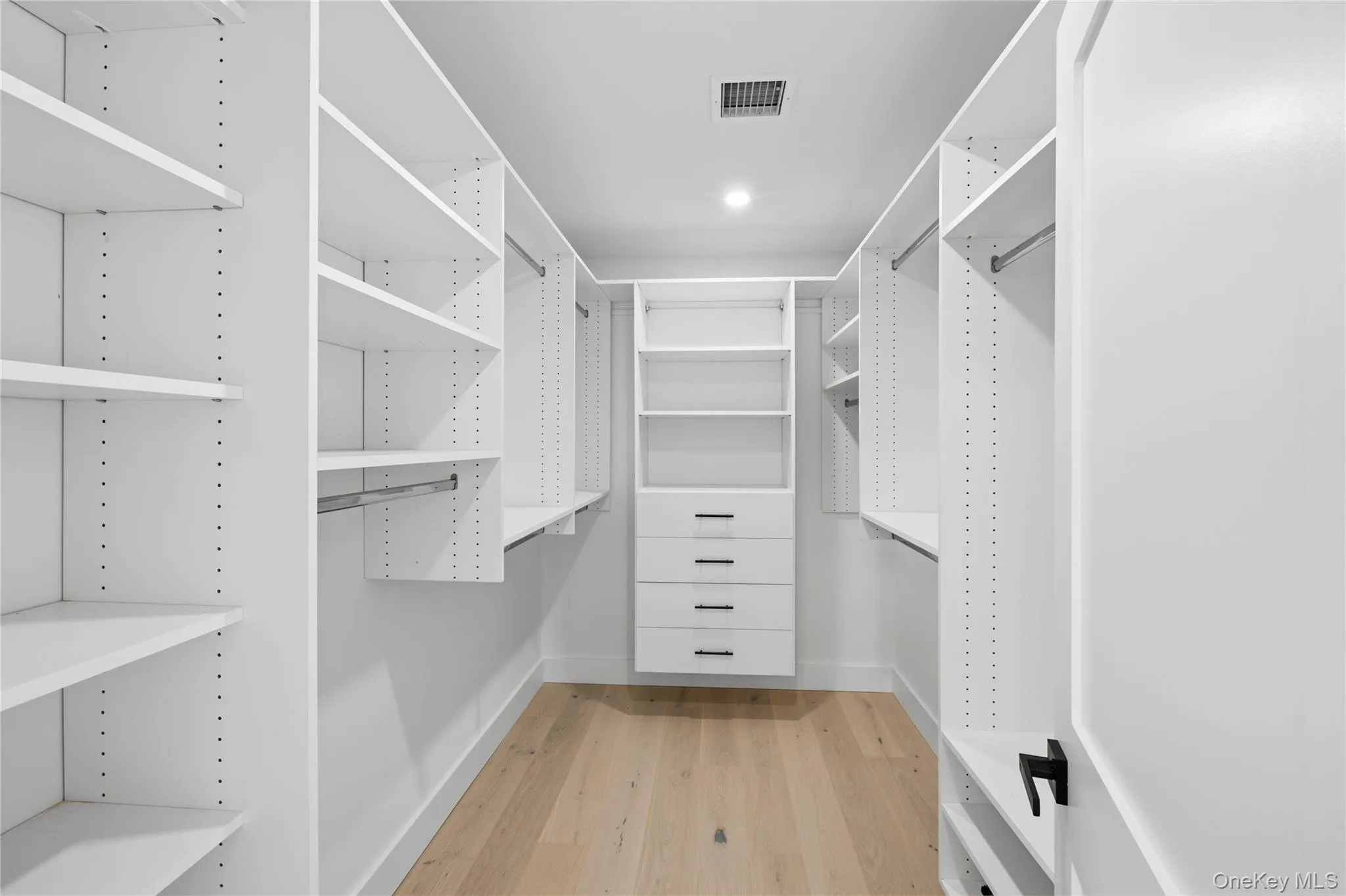 Spacious closet featuring light wood-type flooring Spacious closet featuring light wood-type flooring