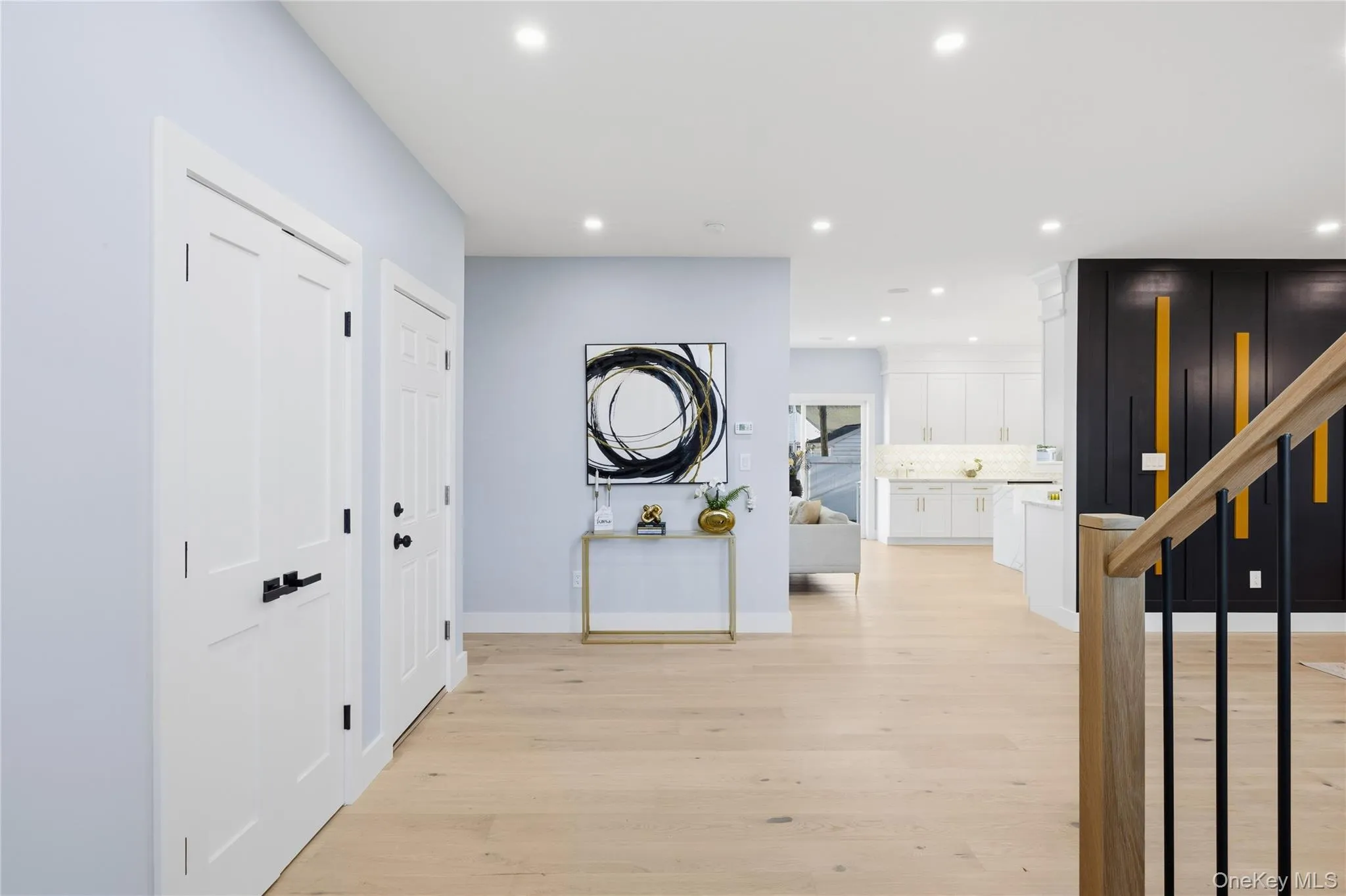 Corridor featuring light wood-style flooring, recessed lighting, and stairs Corridor featuring light wood-style flooring, recessed lighting, and stairs