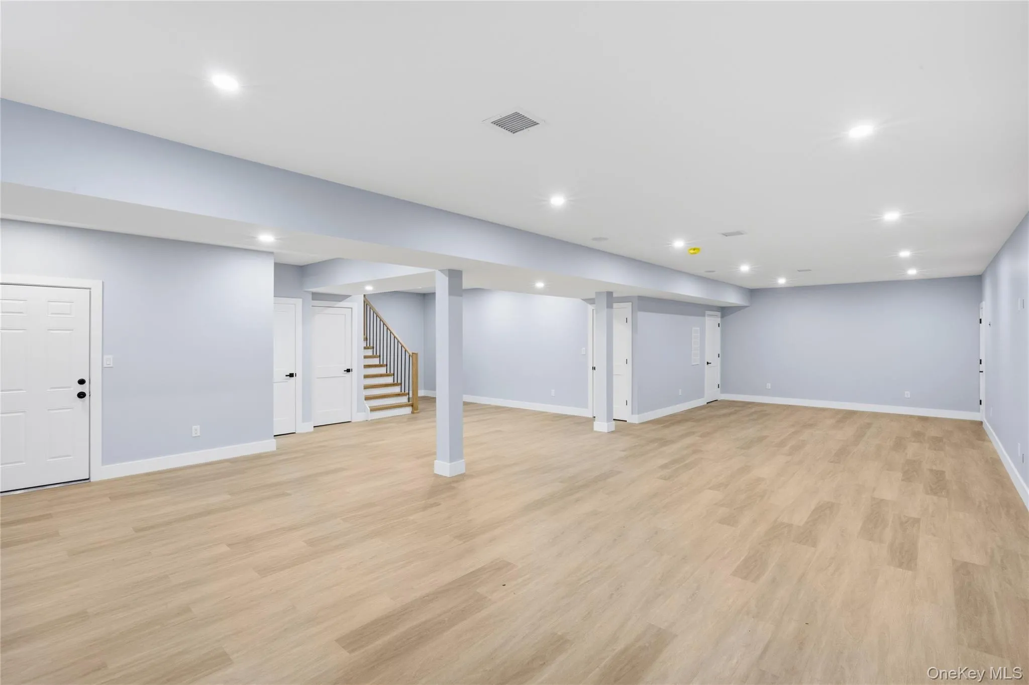Finished below grade area featuring stairway, light wood-style flooring, and recessed lighting Finished below grade area featuring stairway, light wood-style flooring, and recessed lighting