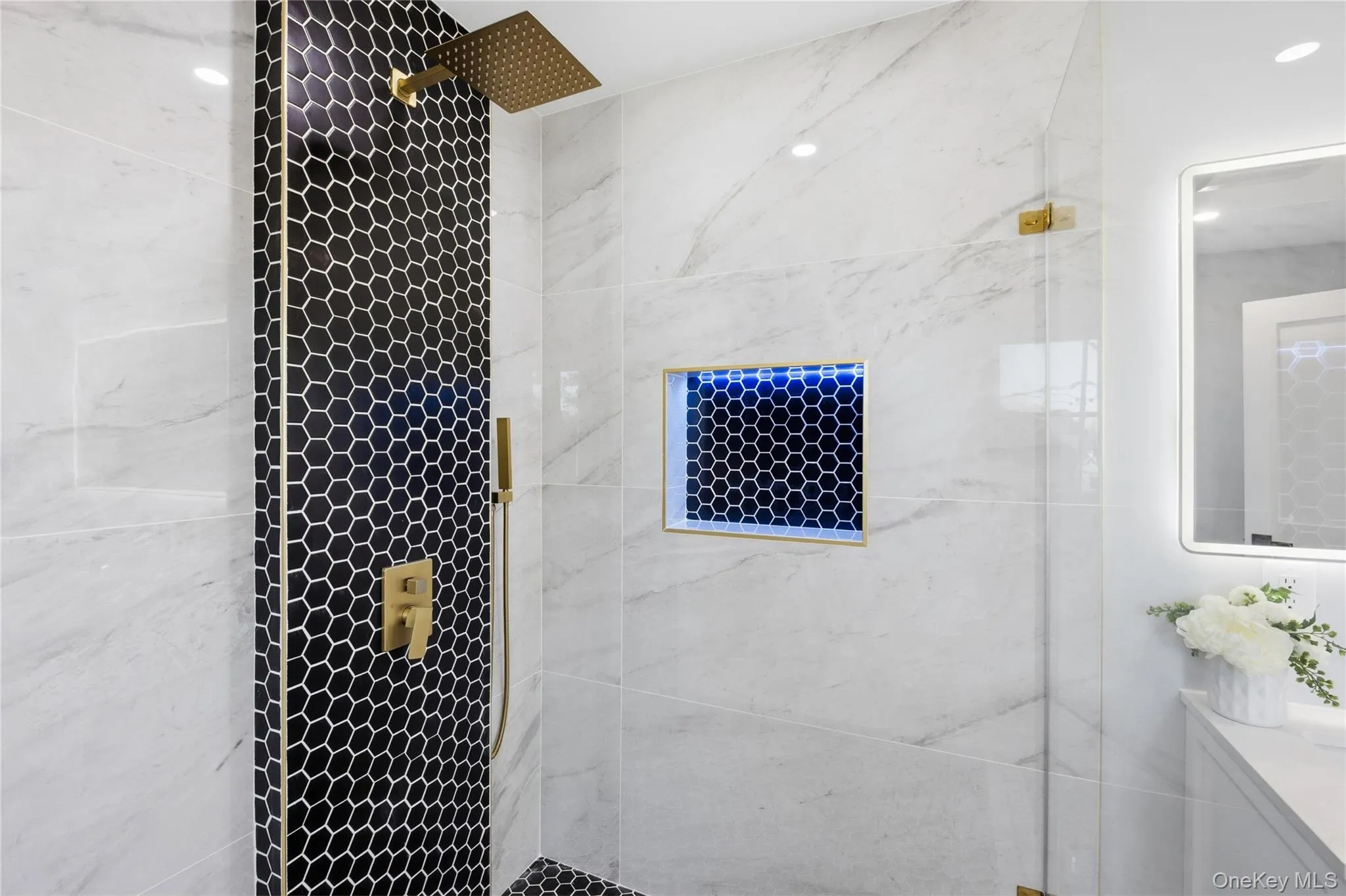 Full bathroom featuring a marble finish shower and vanity Full bathroom featuring a marble finish shower and vanity