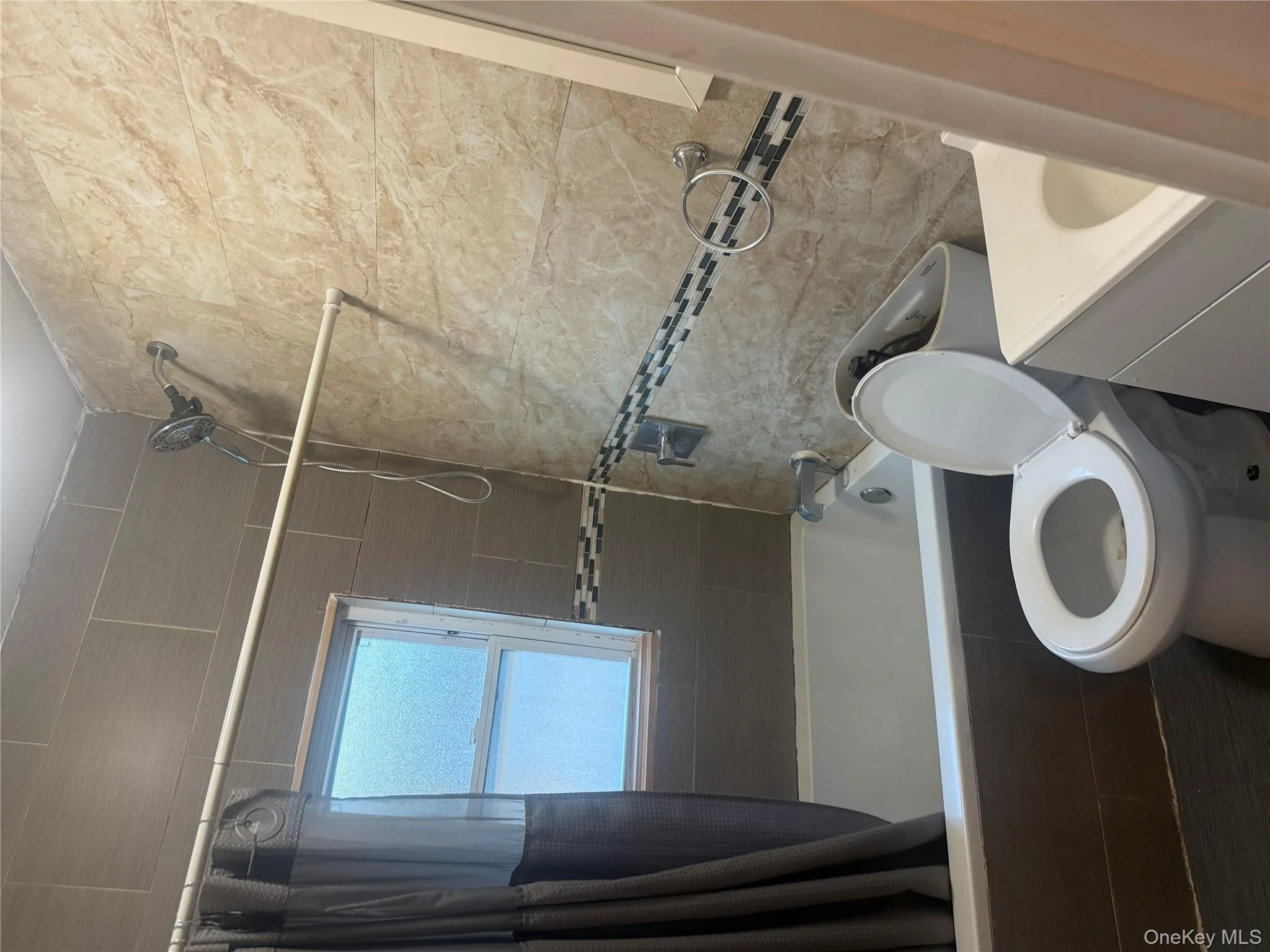 Full bathroom featuring vanity, tiled shower / bath combo, and tile walls Full bathroom featuring vanity, tiled shower / bath combo, and tile walls