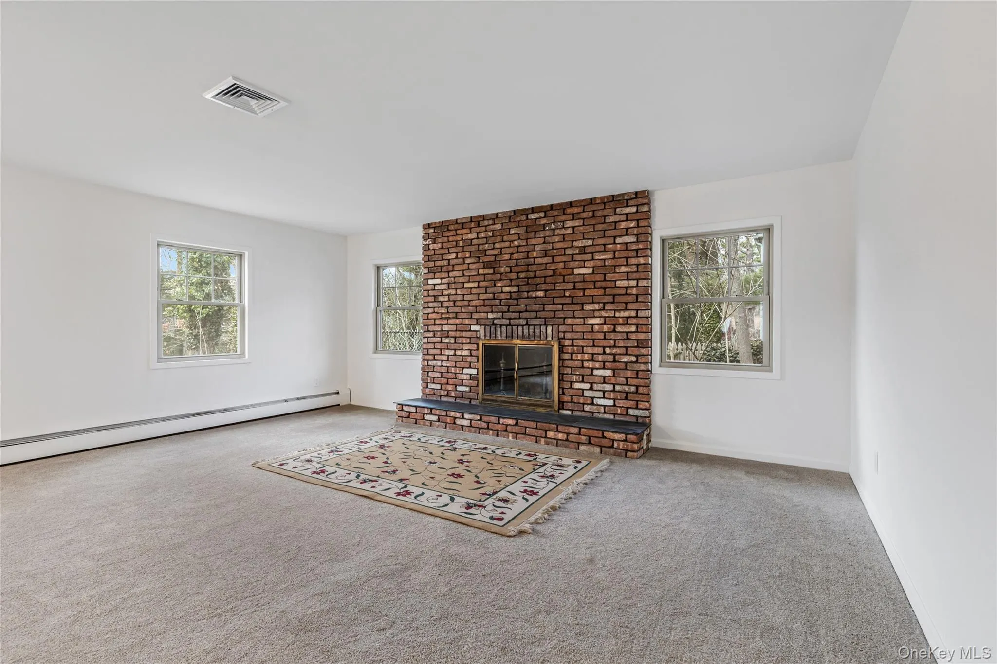 Unfurnished living room with a fireplace, carpet floors, and plenty of natural light Unfurnished living room with a fireplace, carpet floors, and plenty of natural light