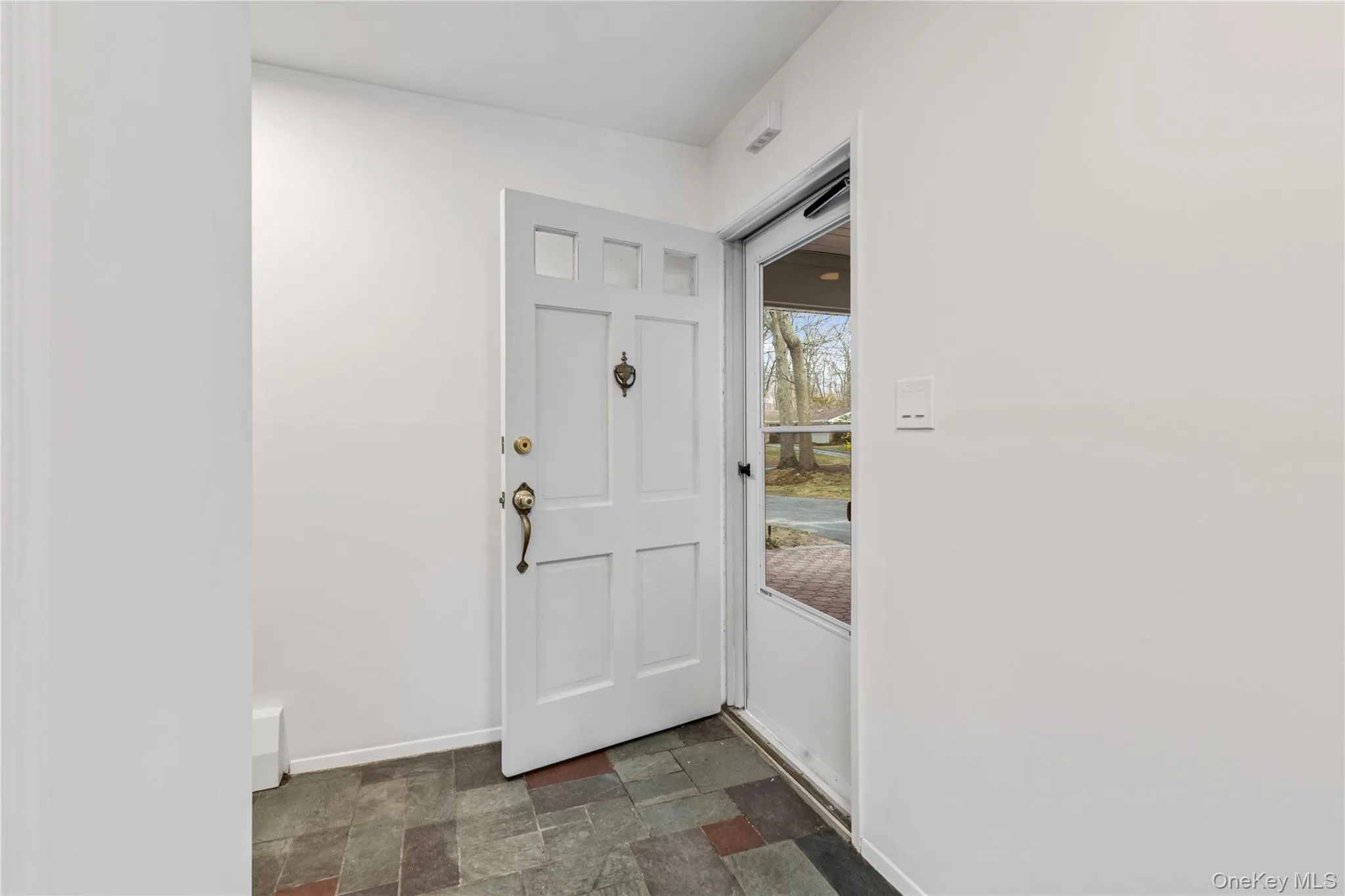 Foyer entrance with stone finish floors and baseboards Foyer entrance with stone finish floors and baseboards