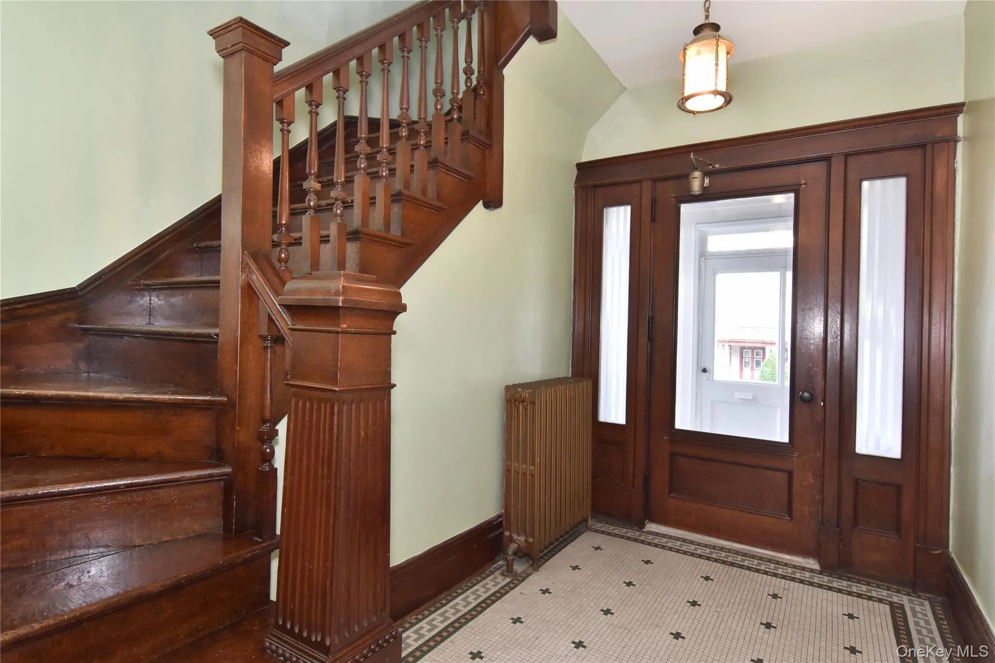 Entrance foyer featuring beautiful oak woodwork, curving stairway, and vaulted ceiling. Entrance foyer featuring beautiful oak woodwork, curving stairway, and vaulted ceiling.