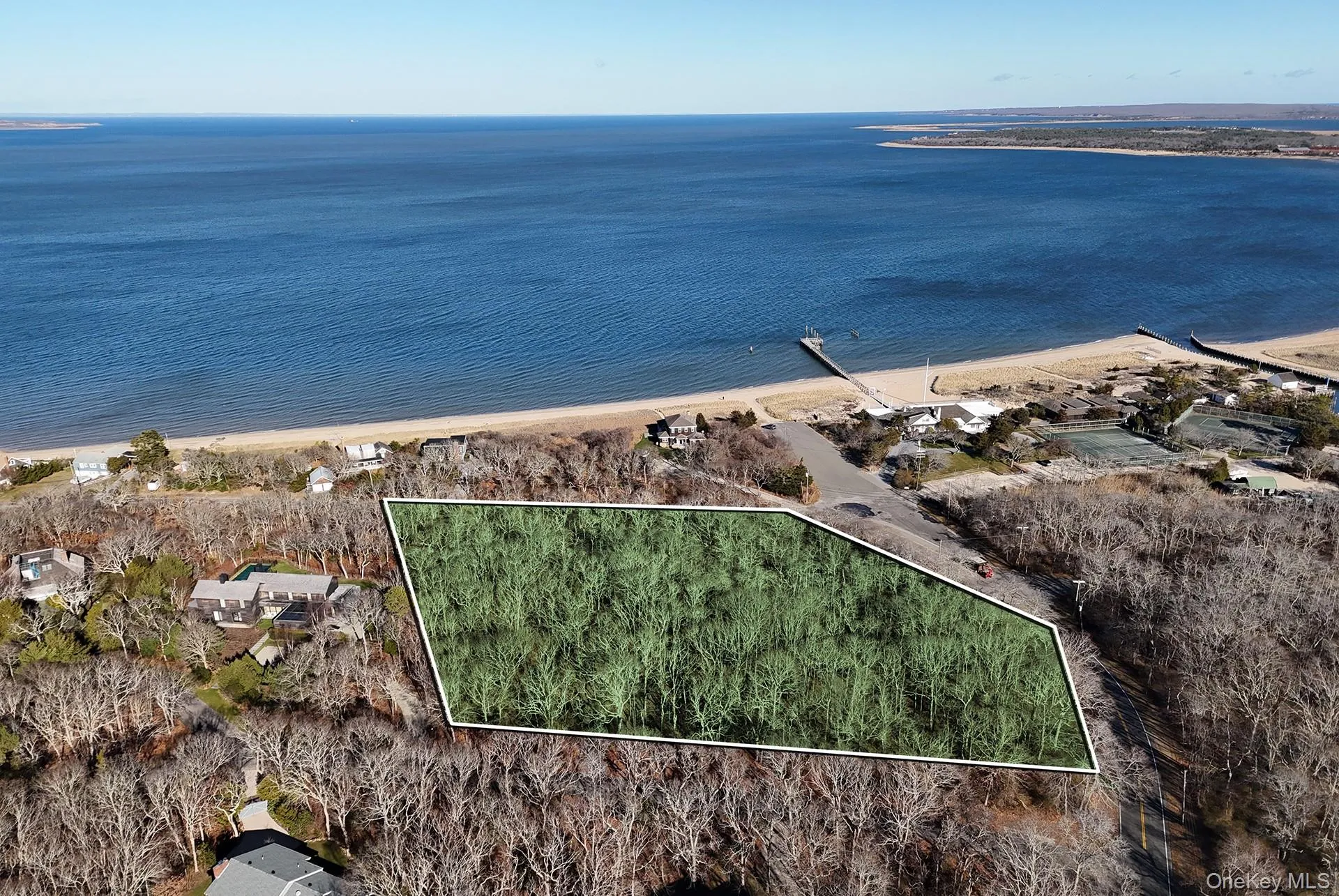 Aerial view of property and surrounding area featuring property parcel outlined and a nearby body of water