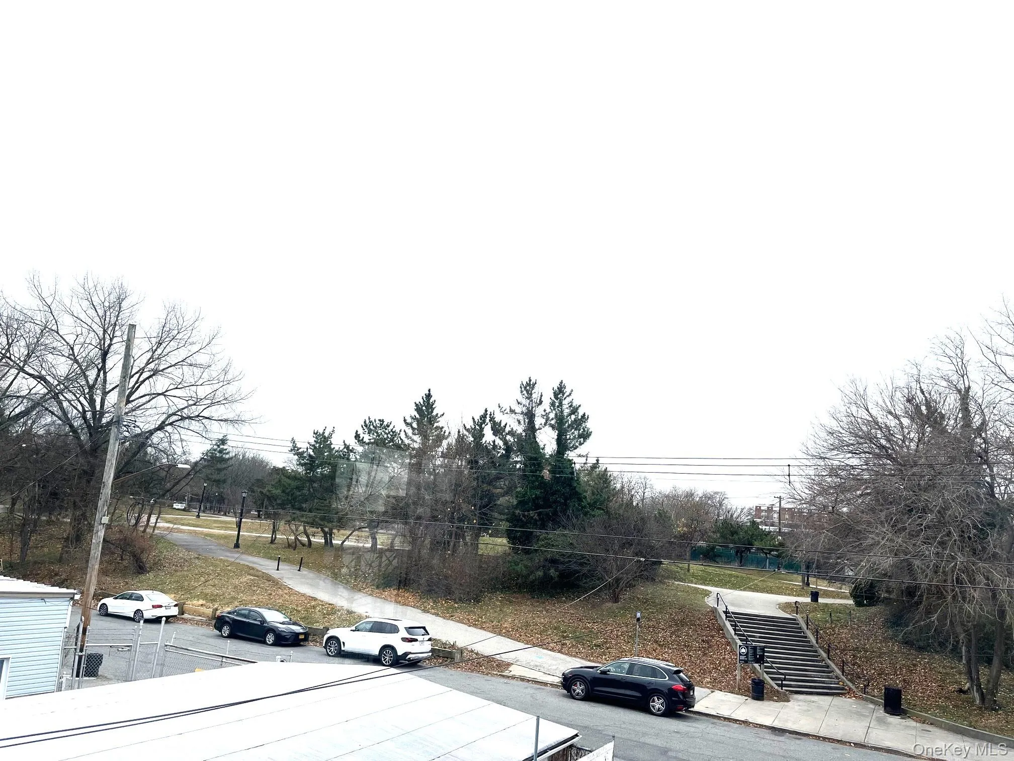 View of asphalt road with sidewalks and curbs View of asphalt road with sidewalks and curbs