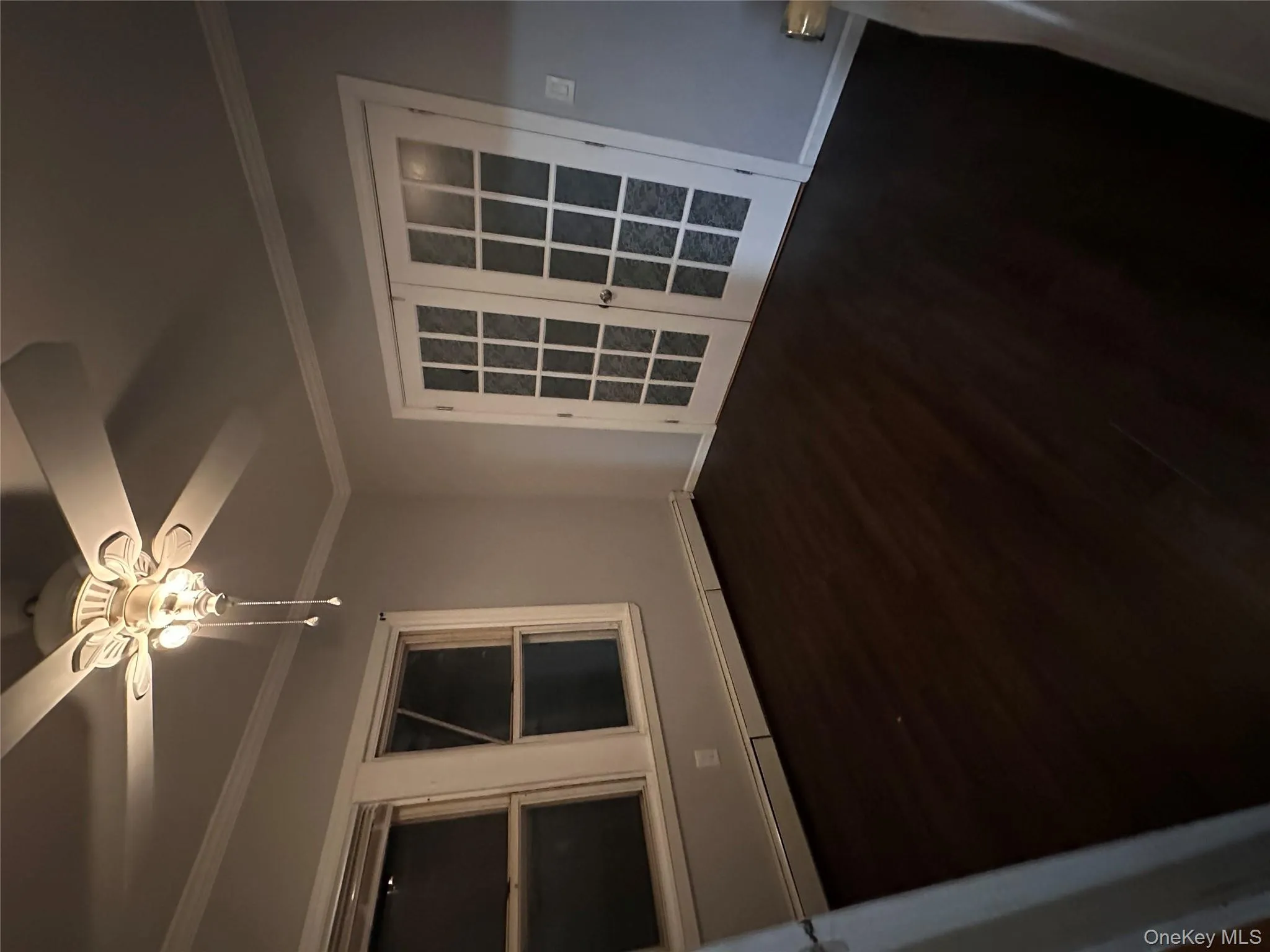 Empty room with crown molding, french doors, a baseboard radiator, dark wood-type flooring, and ceiling fan Empty room with crown molding, french doors, a baseboard radiator, dark wood-type flooring, and ceiling fan