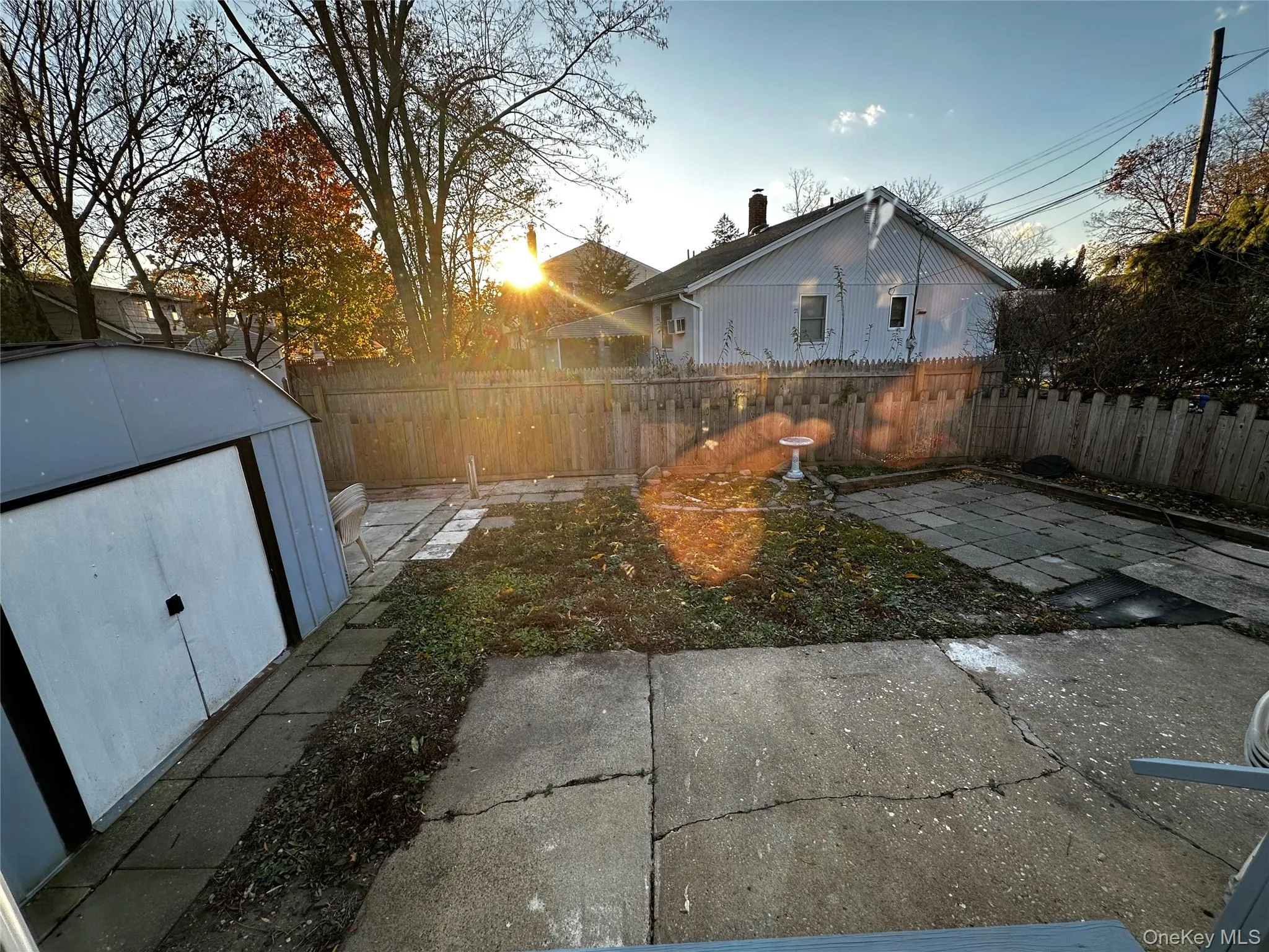 Fenced backyard featuring a patio area and a storage shed Fenced backyard featuring a patio area and a storage shed