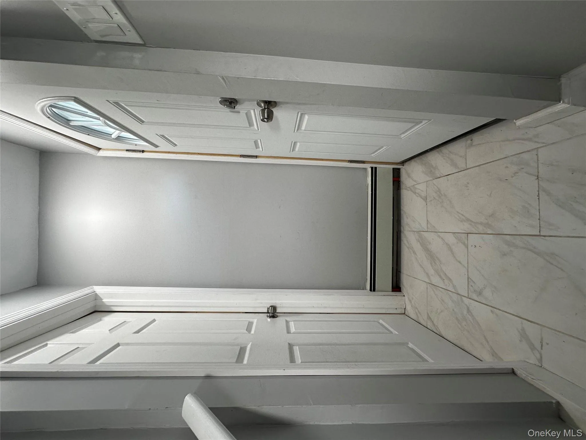 Entryway featuring marble finish floors and a baseboard heating unit Entryway featuring marble finish floors and a baseboard heating unit