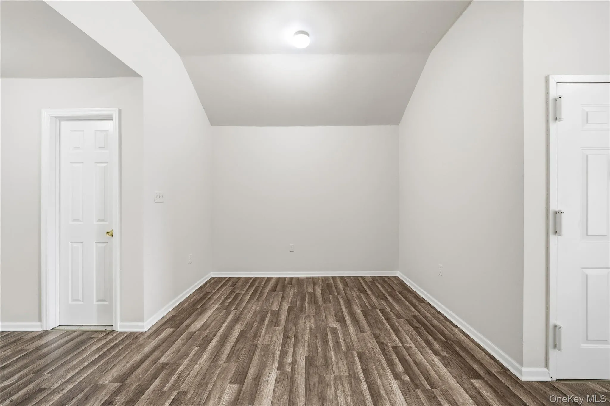 Bonus room with lofted ceiling and dark wood-style flooring Bonus room with lofted ceiling and dark wood-style flooring