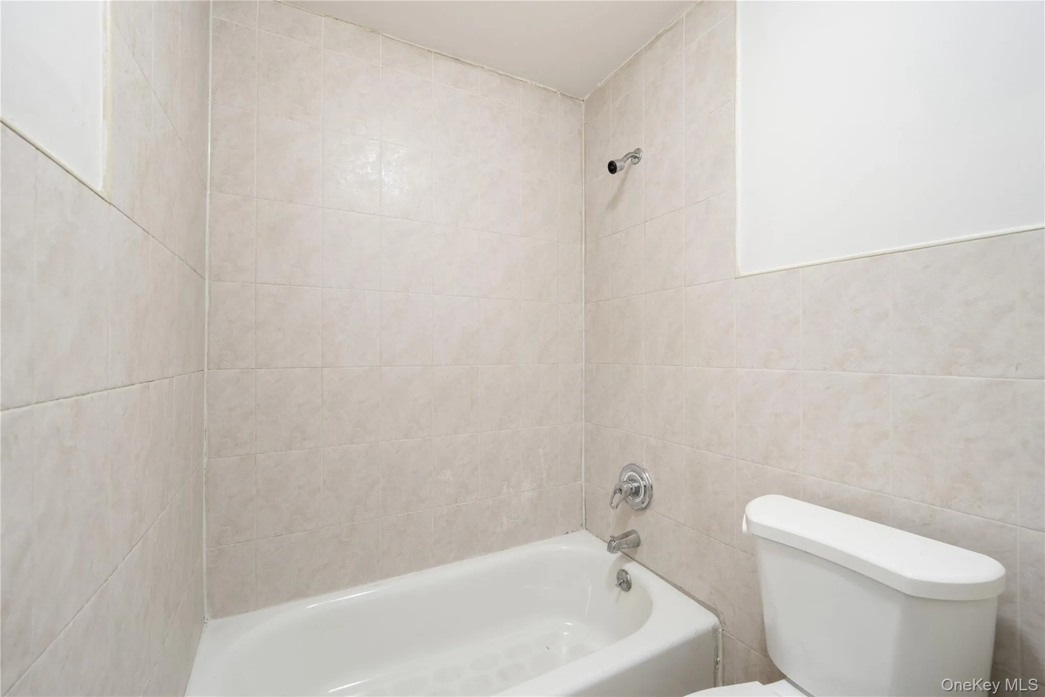Full bath with shower / tub combination and tile walls Full bath with shower / tub combination and tile walls