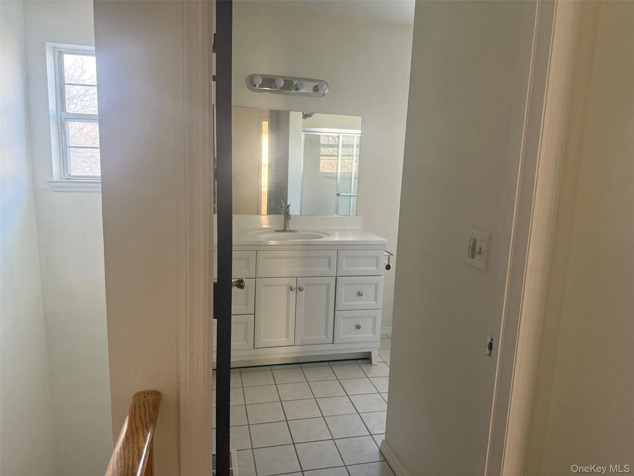 Bathroom with vanity, plenty of natural light, and light tile patterned floors Bathroom with vanity, plenty of natural light, and light tile patterned floors