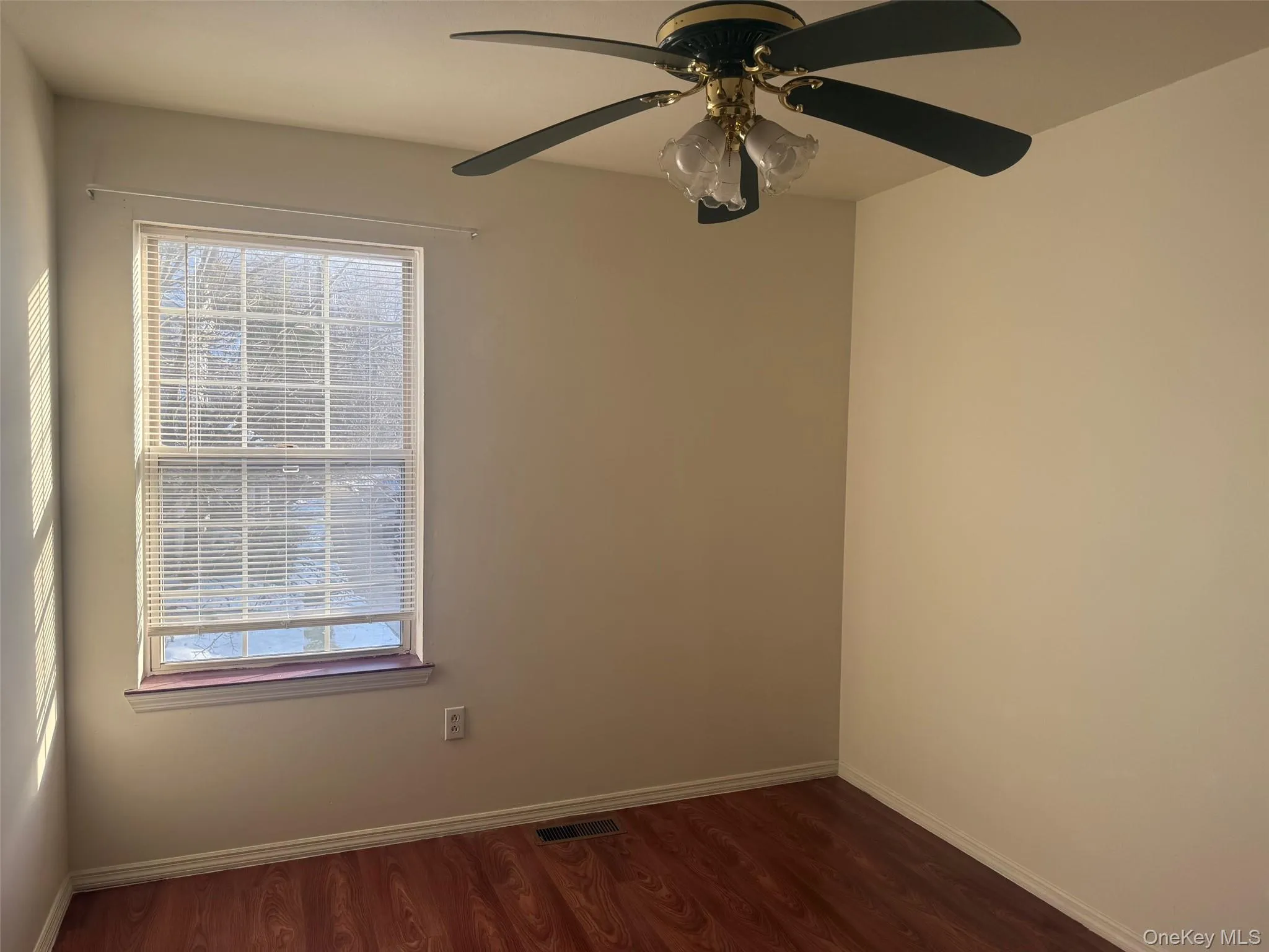 Empty room featuring dark wood-type flooring and a ceiling fan Empty room featuring dark wood-type flooring and a ceiling fan