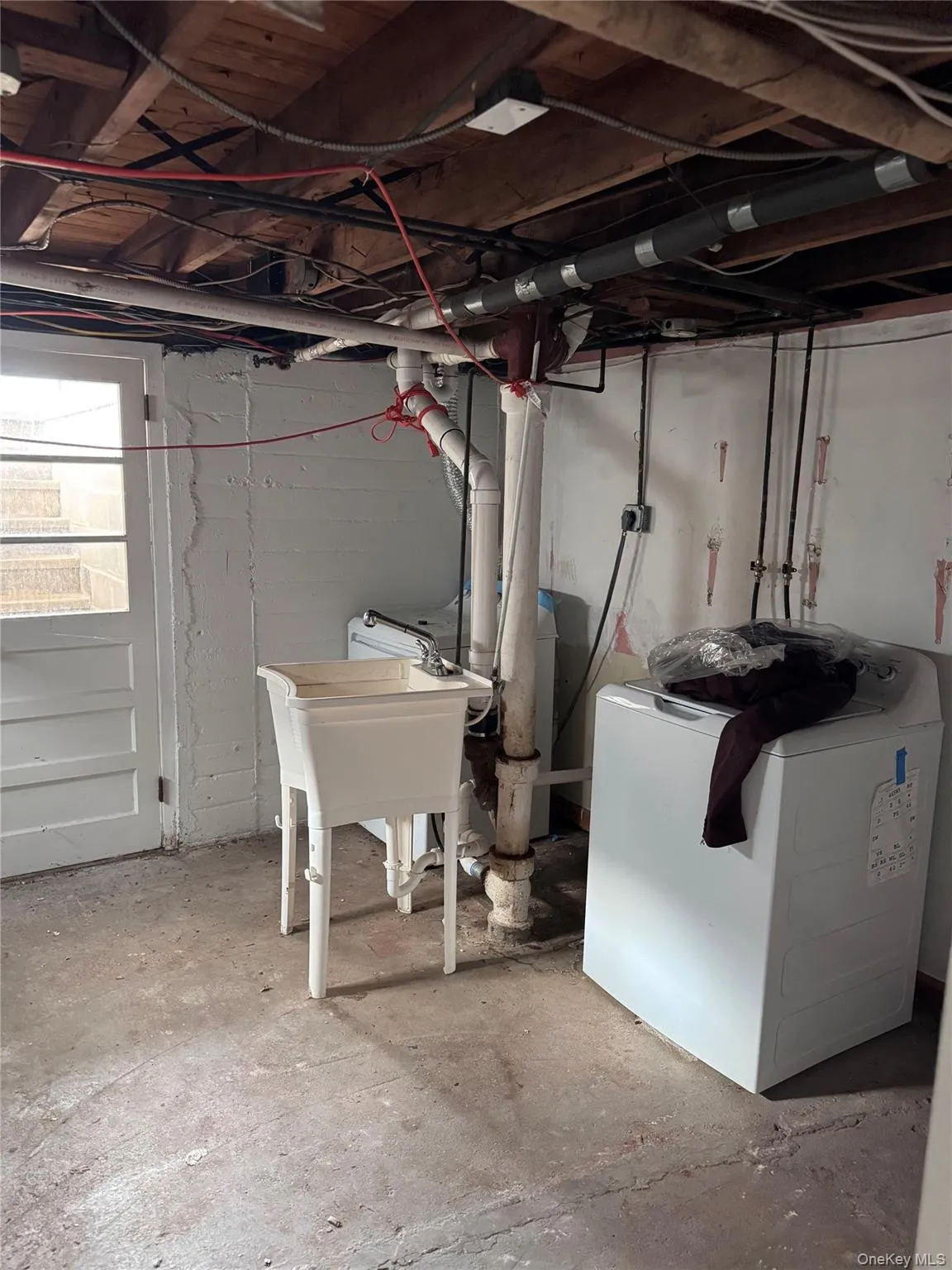 Below grade area featuring washer / dryer and a sink Below grade area featuring washer / dryer and a sink