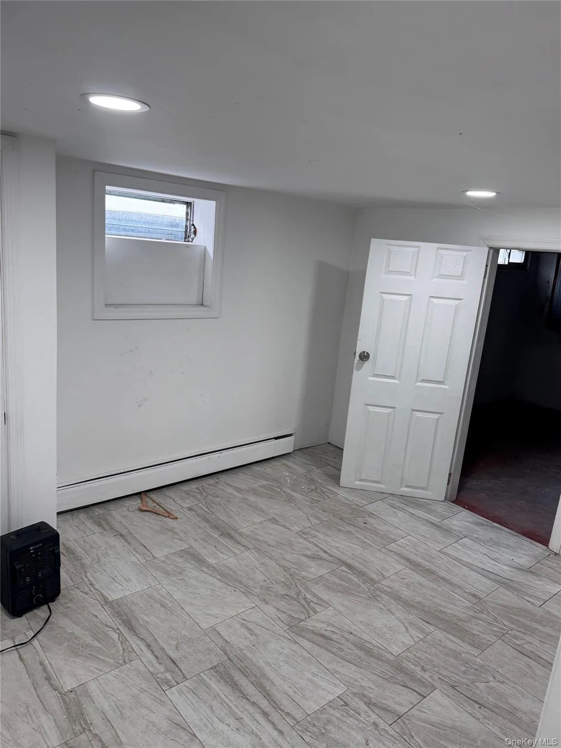 Below grade area featuring baseboard heating and recessed lighting Below grade area featuring baseboard heating and recessed lighting