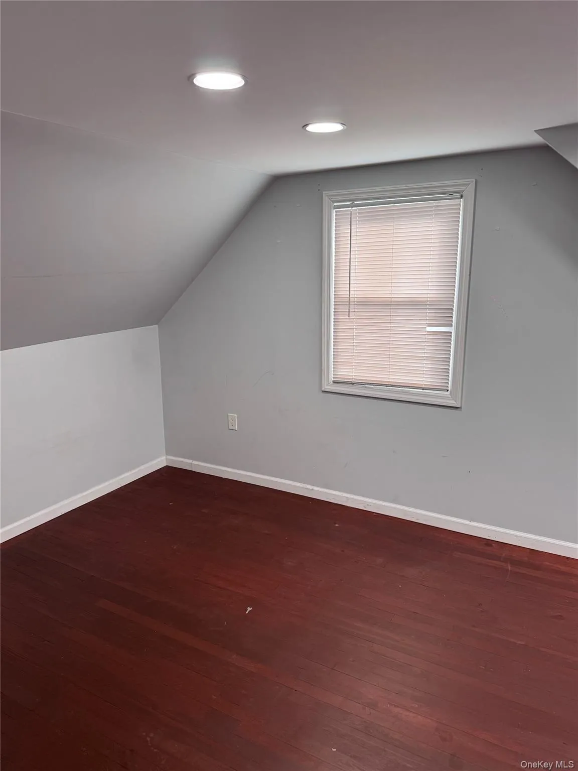 Bonus room featuring dark wood-style flooring and vaulted ceiling Bonus room featuring dark wood-style flooring and vaulted ceiling