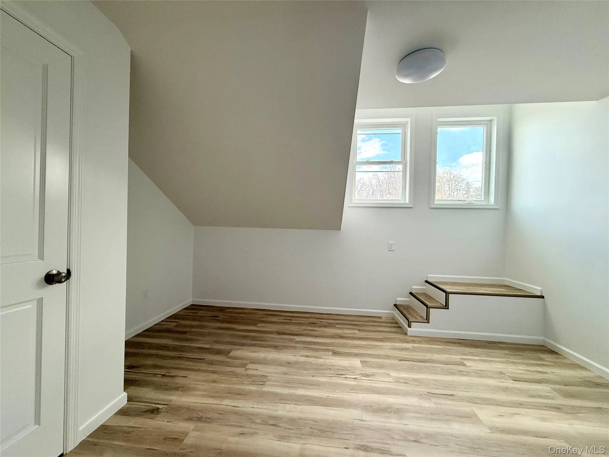 Additional living space with light wood-style floors and lofted ceiling Additional living space with light wood-style floors and lofted ceiling