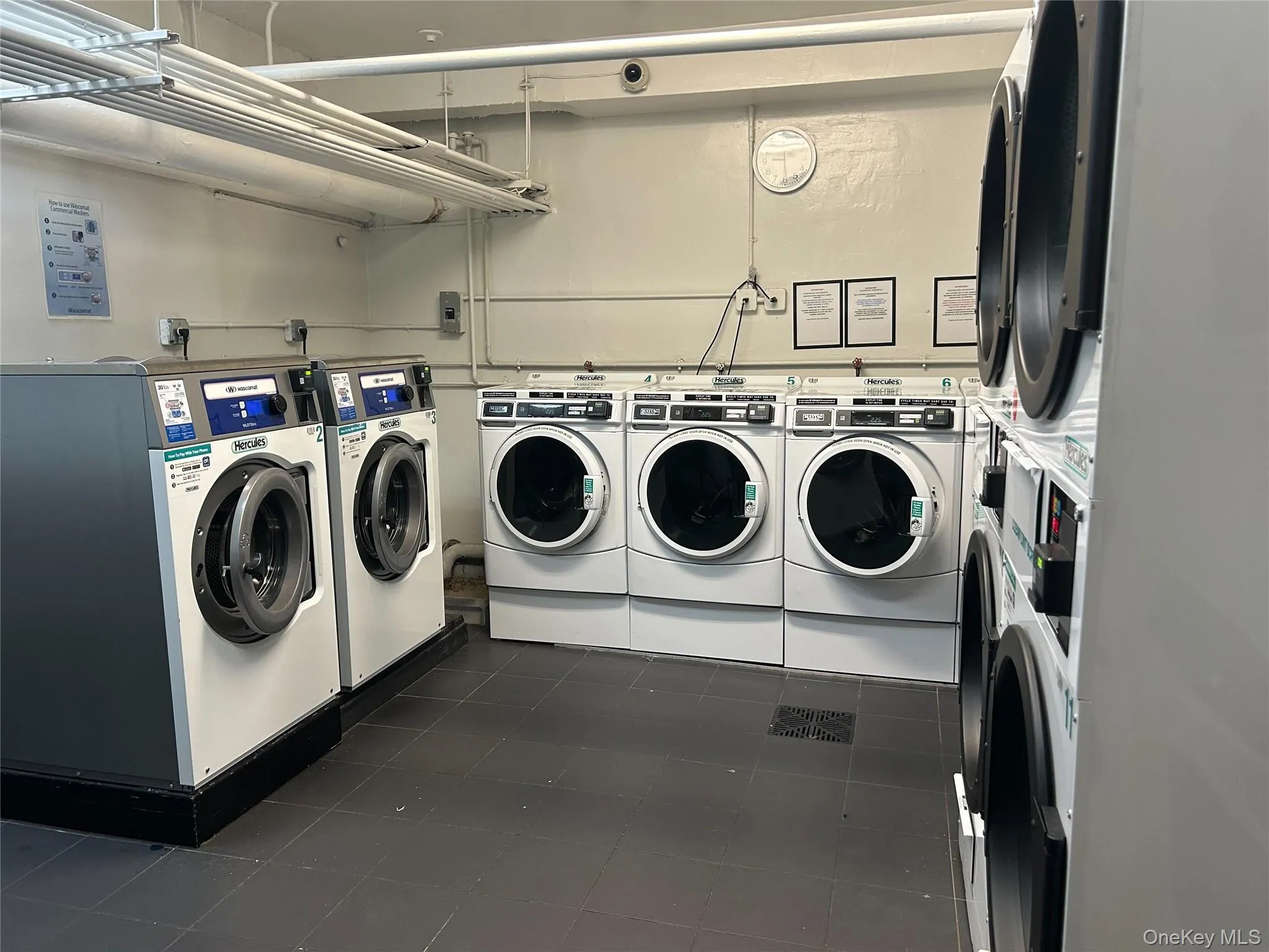 Shared laundry with dark tile patterned flooring and washing machine and clothes dryer Shared laundry with dark tile patterned flooring and washing machine and clothes dryer