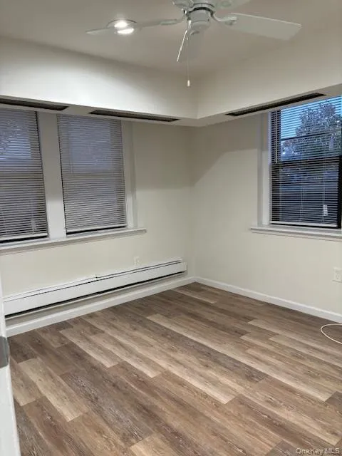 Spare room featuring baseboard heating, light wood-style floors, and ceiling fan Spare room featuring baseboard heating, light wood-style floors, and ceiling fan