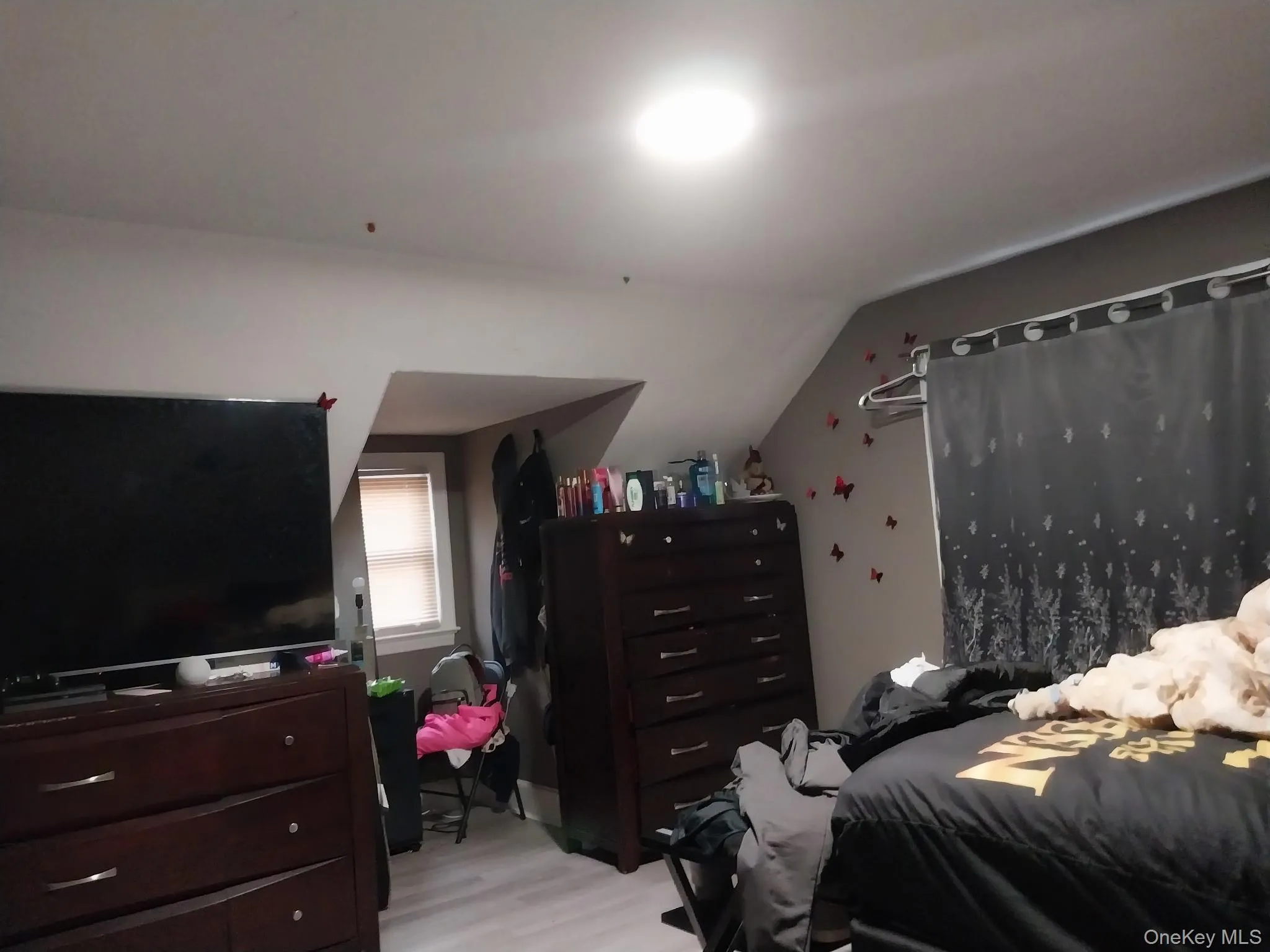 Bedroom with lofted ceiling and light wood-style flooring Bedroom with lofted ceiling and light wood-style flooring