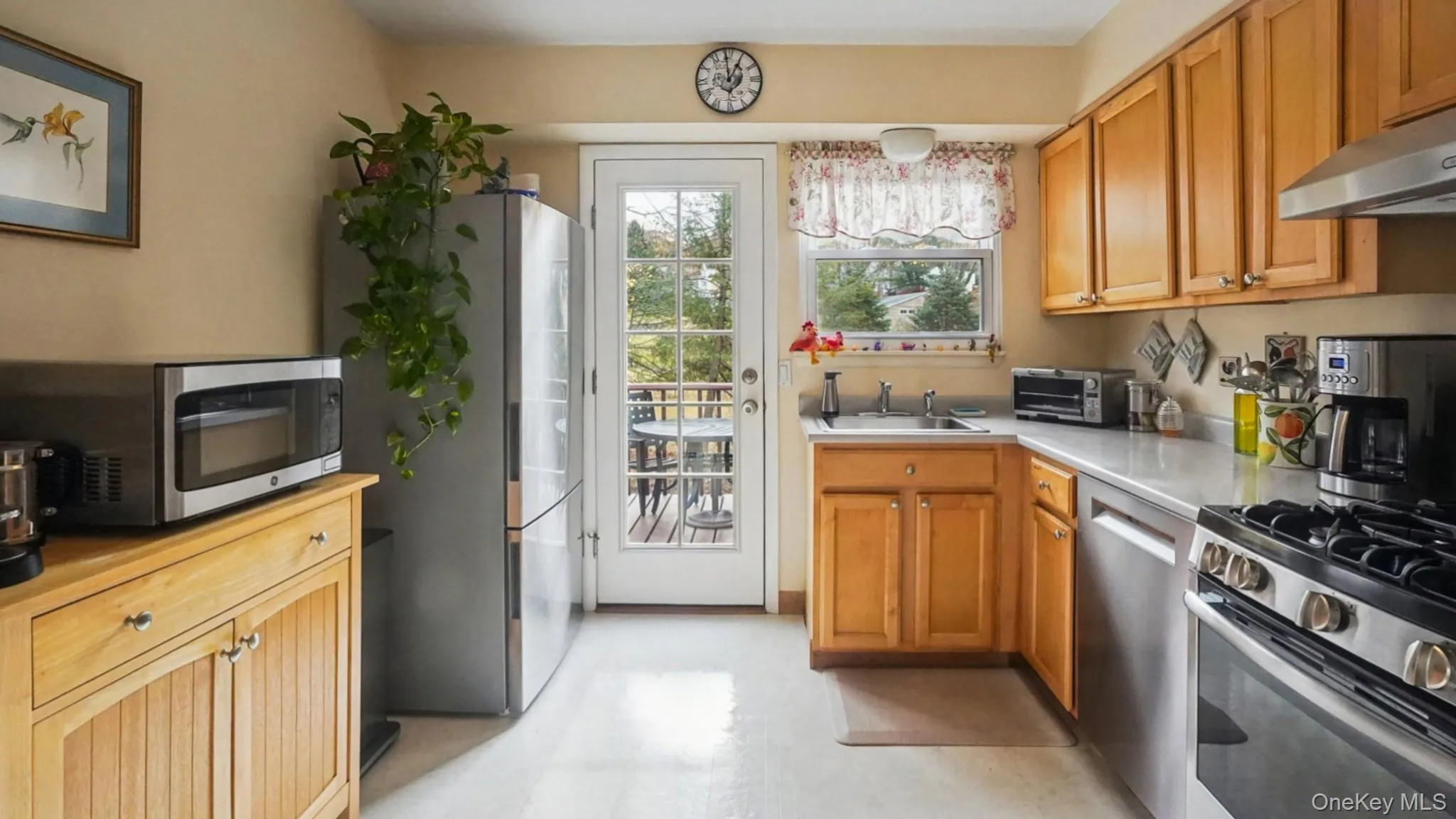 Kitchen with light countertops, appliances with stainless steel finishes, brown cabinetry, and light floors Kitchen with light countertops, appliances with stainless steel finishes, brown cabinetry, and light floors