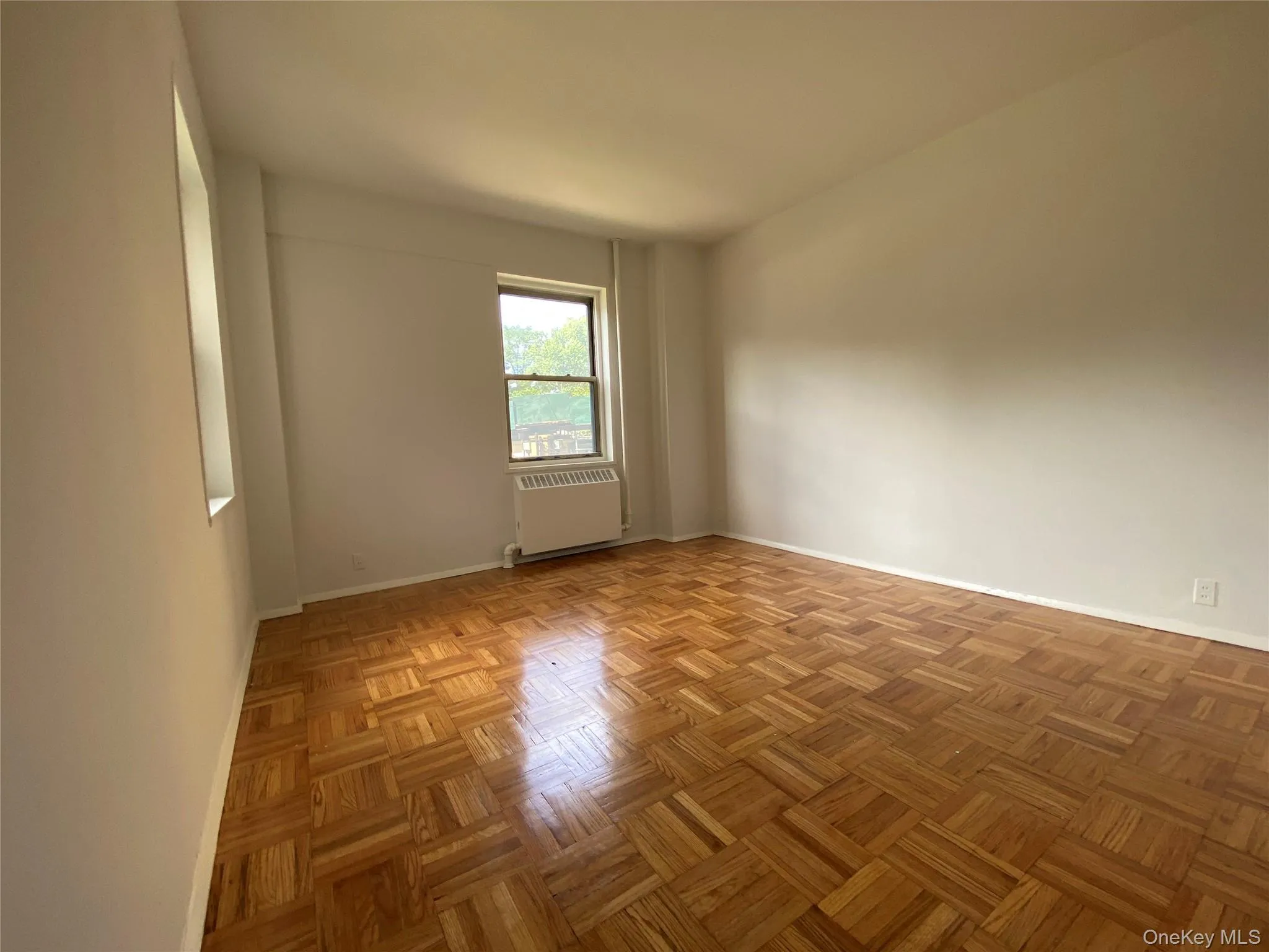 Spare room with radiator heating unit and baseboards Spare room with radiator heating unit and baseboards