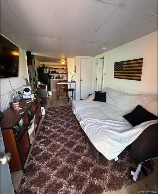 Bedroom with black fridge with ice dispenser and wood finished floors Bedroom with black fridge with ice dispenser and wood finished floors