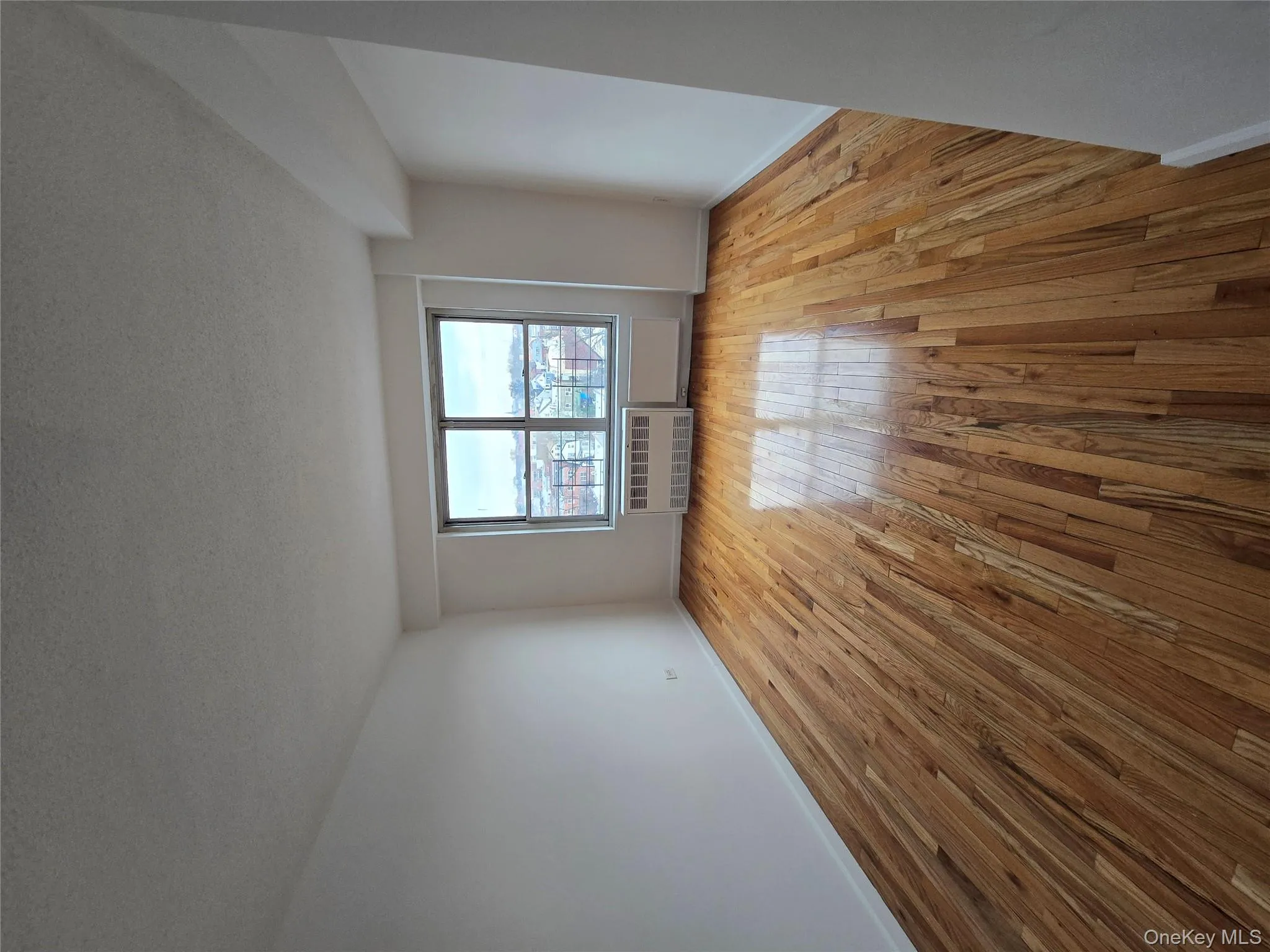 Spare room featuring a textured ceiling, light wood finished floors, and radiator Spare room featuring a textured ceiling, light wood finished floors, and radiator