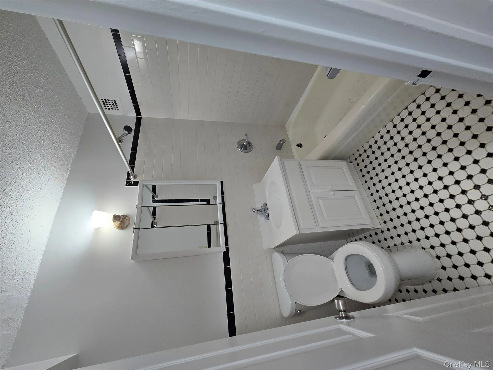 Full bath featuring vanity, shower / bathtub combination, tile walls, a textured ceiling, and wainscoting Full bath featuring vanity, shower / bathtub combination, tile walls, a textured ceiling, and wainscoting
