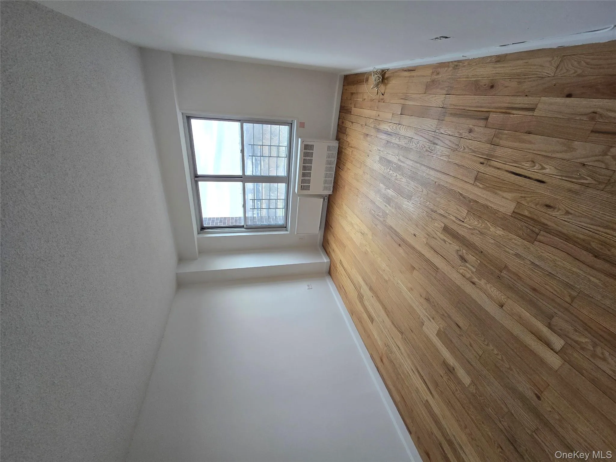 Spare room featuring a textured ceiling, light wood-type flooring, and radiator Spare room featuring a textured ceiling, light wood-type flooring, and radiator