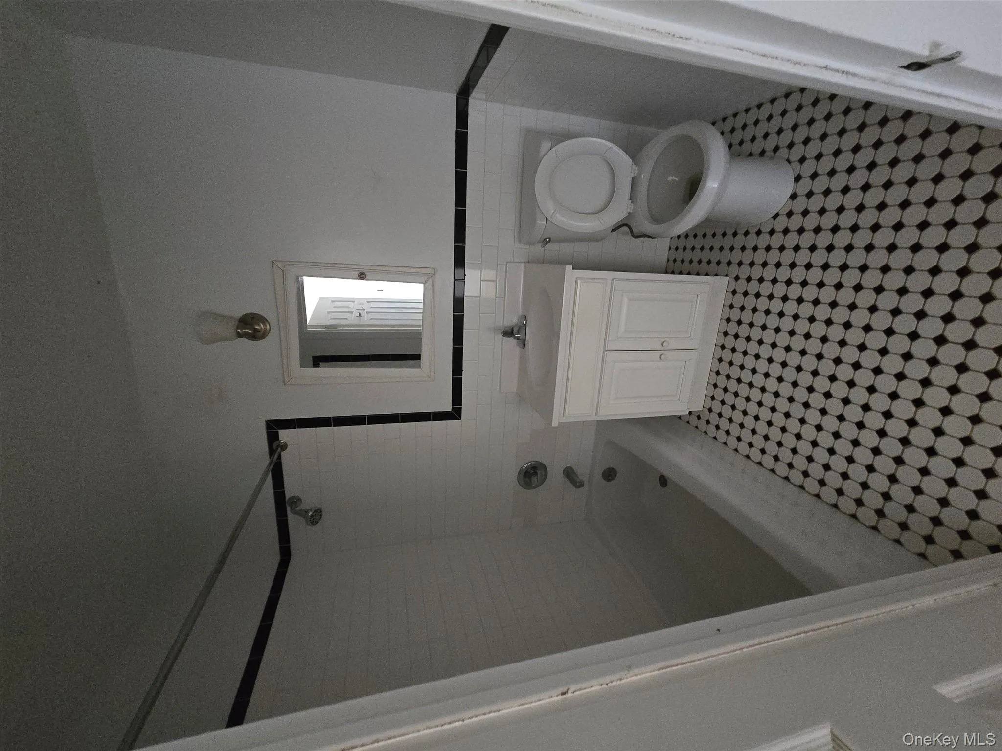 Full bathroom featuring vanity, tile walls, washtub / shower combination, and wainscoting Full bathroom featuring vanity, tile walls, washtub / shower combination, and wainscoting