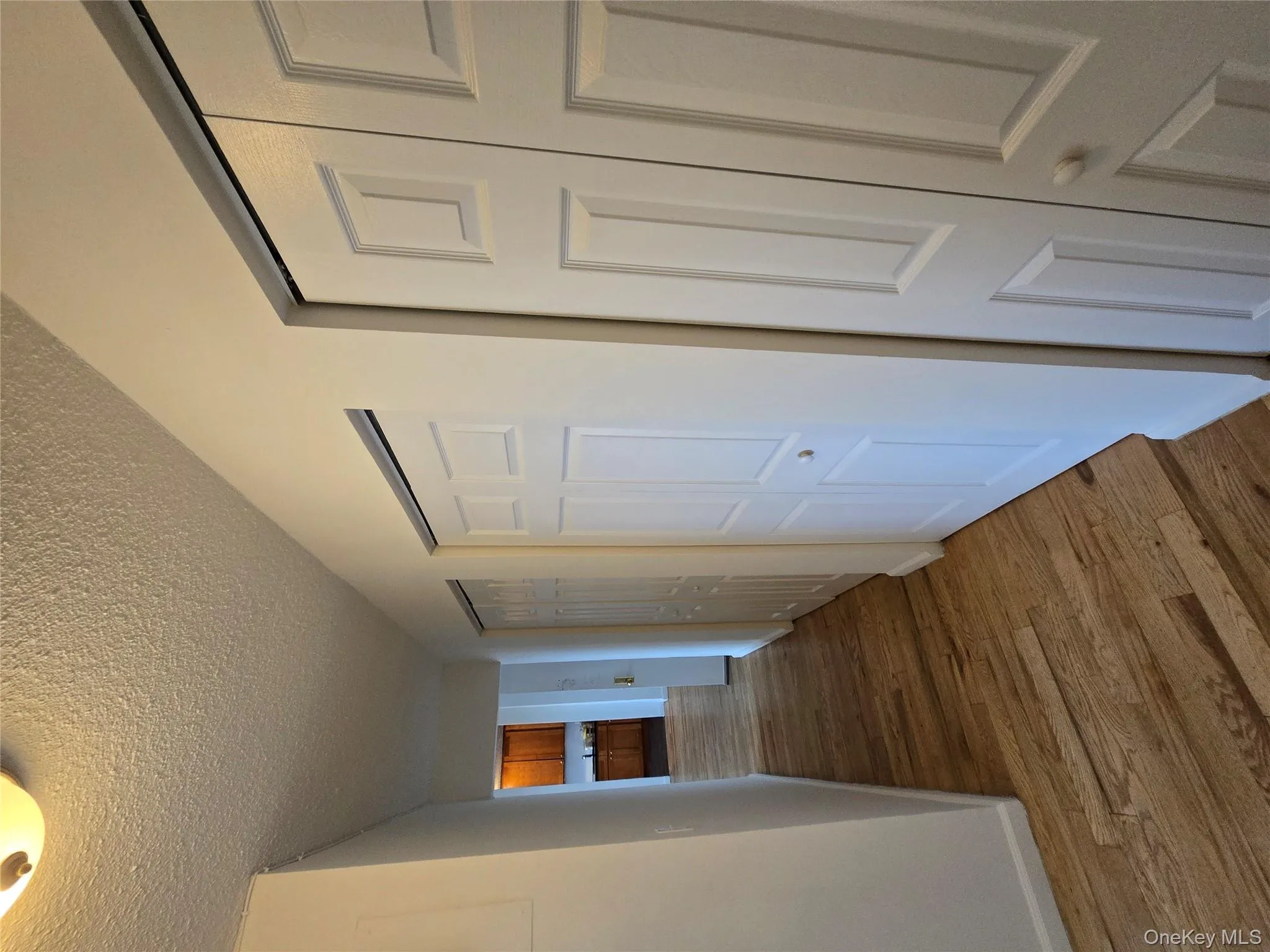 Hallway with wood finished floors and a textured ceiling Hallway with wood finished floors and a textured ceiling