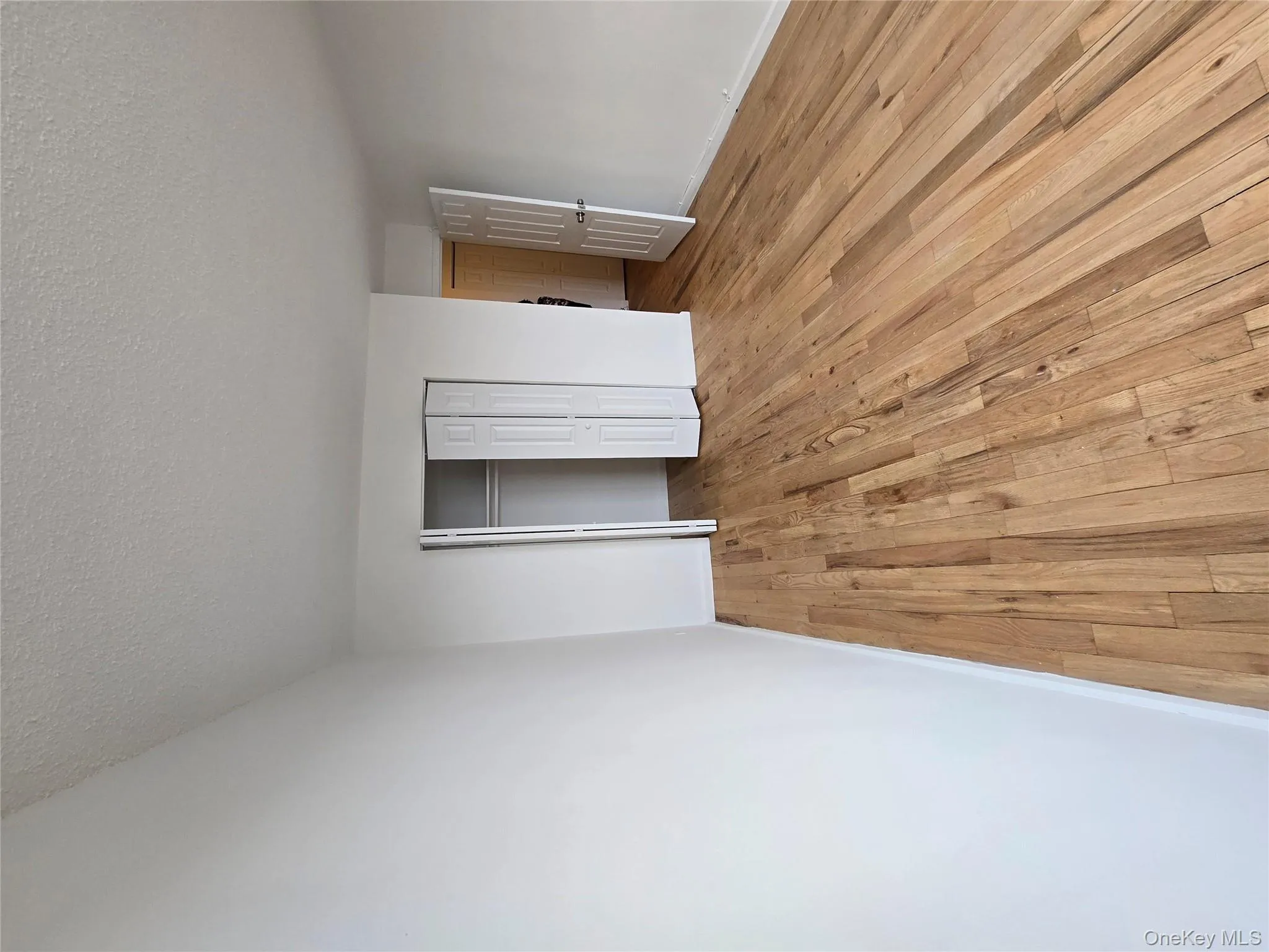 Unfurnished bedroom featuring light wood finished floors, a textured ceiling, and a closet Unfurnished bedroom featuring light wood finished floors, a textured ceiling, and a closet